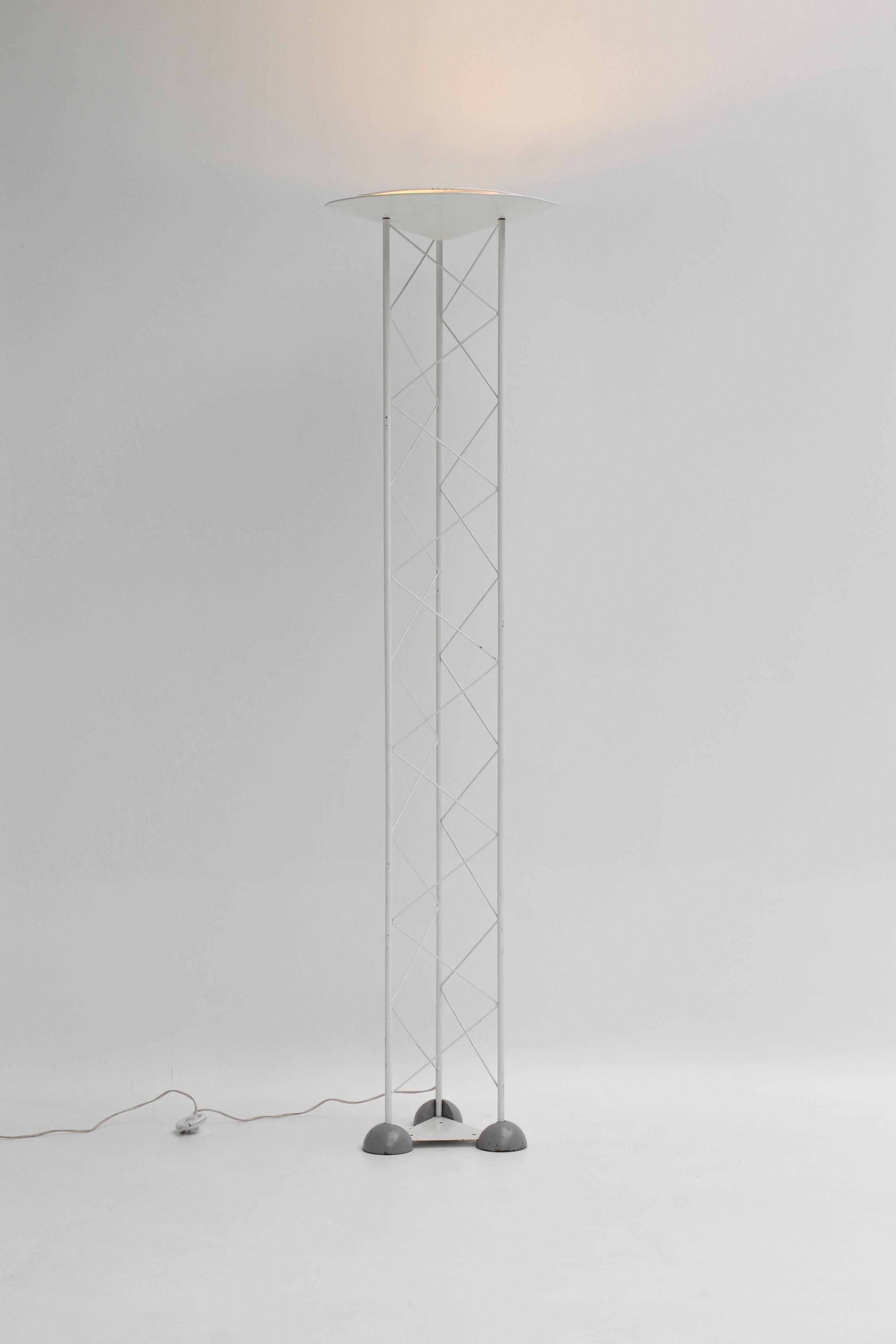 Lampadaire italien Alta Line, réalisé dans les années 1980.
Son design architectural, inspiré des structures industrielles, marie un treillis métallique léger à une base en métal et demi-sphères laquées grises.

Le réflecteur en métal blanc diffuse