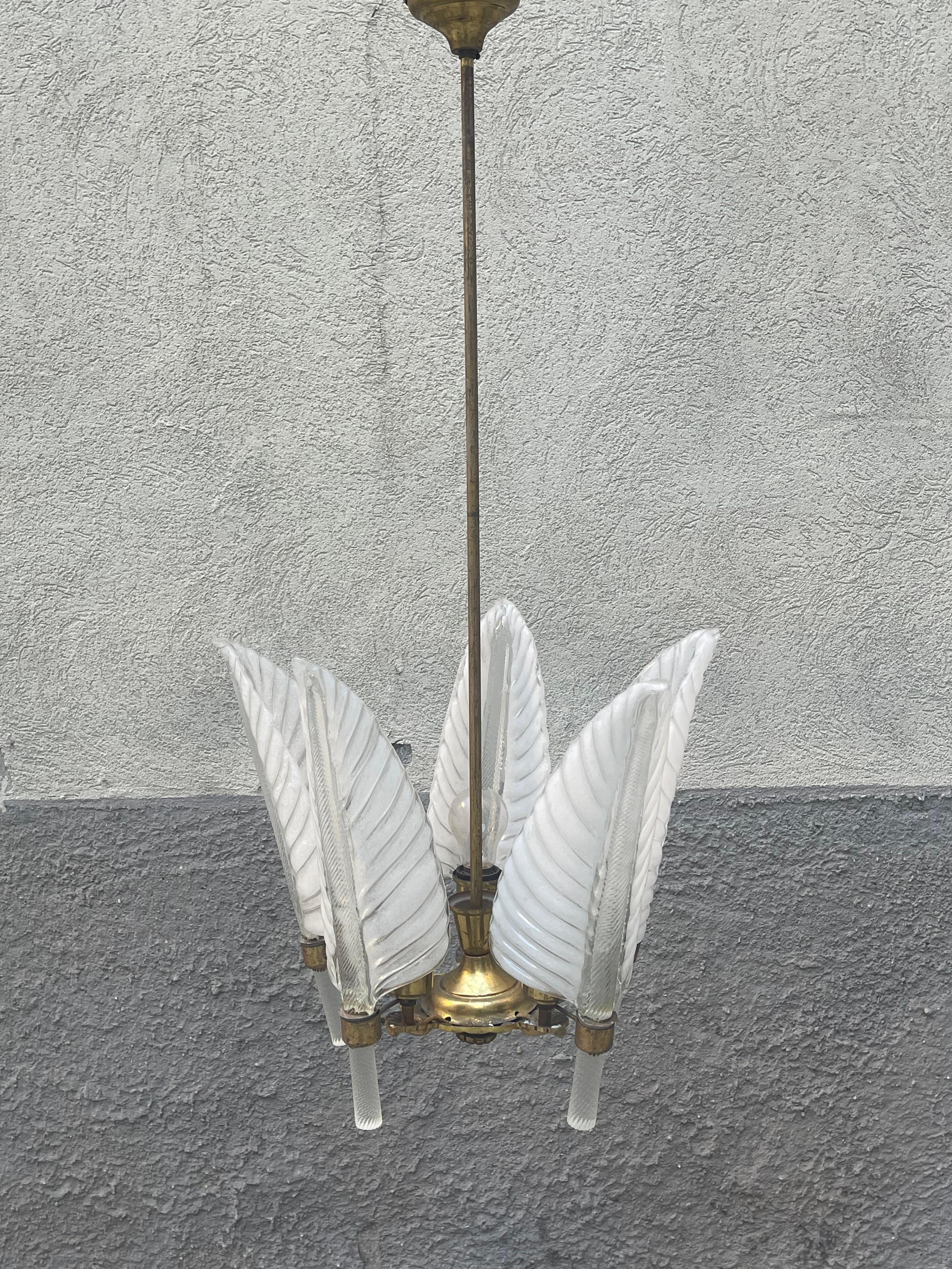 Refined Murano chandelier by Archimede Seguso, designed and made in the 1940s.
A gilded bronze casting houses five magnificent blown glass leaves and twisted stem, a full 39cm high.
Each of these leaves hides a light bulb that is illuminated by