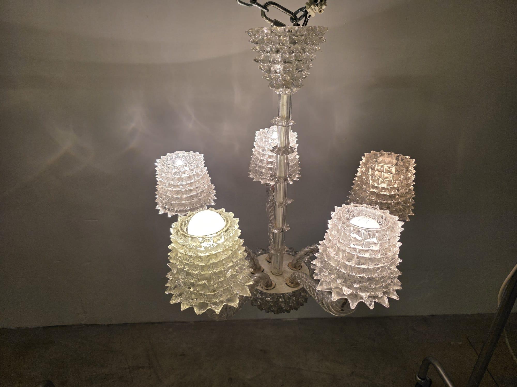 Barovier & Toso Lustre rostrato à 5 lumières.

Élégant lustre à 5 lumières.

En verre de Murano rostrato des années 1940.

La rostration du verre est une technique spéciale inventée par Ercole Barovier qui consiste à tirer le verre chaud avec une