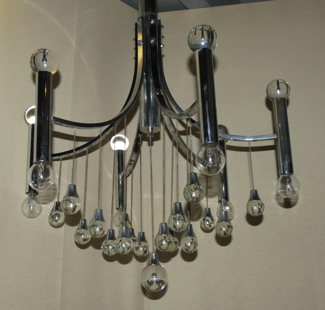 Elegant six-light chandelier produced in the early 1970s in chrome-plated steel and crystal, by master Angelo Gaetano Sciolari (1927-1994), restored and ready to be placed.
The chrome-plated frame supports 6 chrome-plated steel tubes with lower