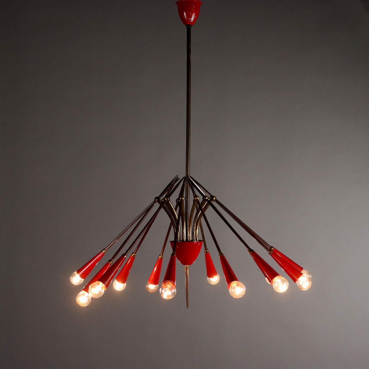 Suspension lamp of Italian manufacture, made around the middle of the 20th century. In good original condition, this twelve-arm chandelier features a brass frame and red lacquered aluminum cone shades with patina of the time. 