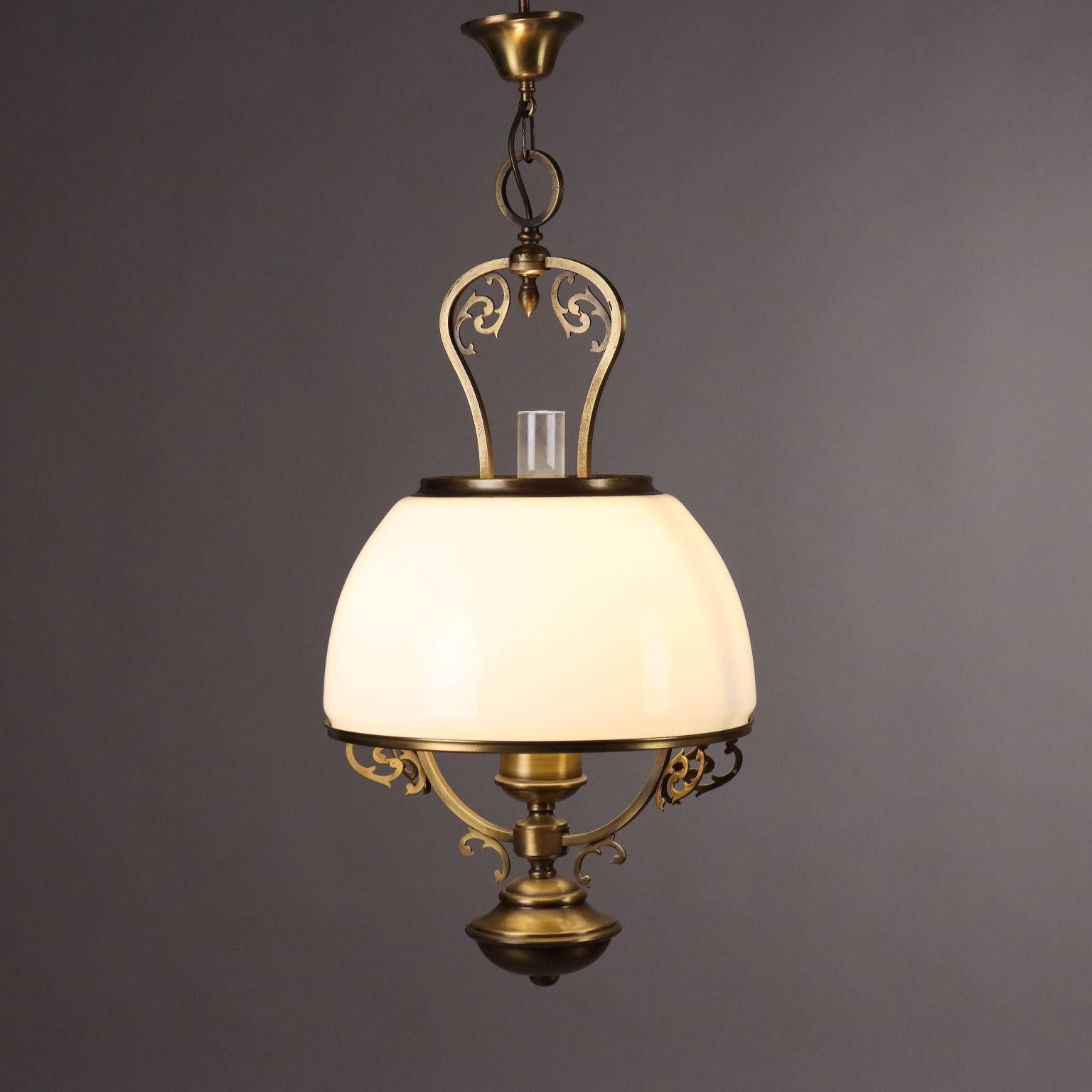 Fabricado como un farol de aceite con soporte de latón y cristal opalino blanco, en el interior campana de cristal transparente.