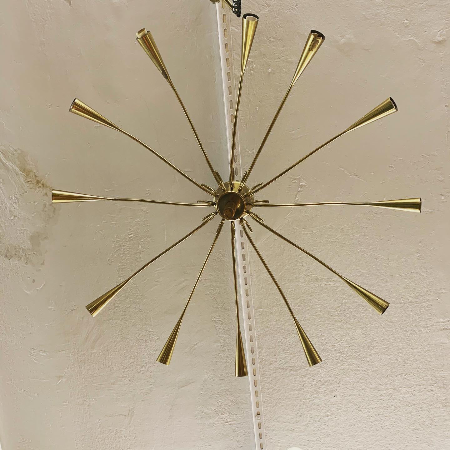Mid-century Italian-made brass chandelier attributed to Oscar Torlasco. Ceiling lamp of considerable size  12-light Sputnik-style polished brass measuring 95 cm in diameter. A quality item with a beautiful patina that will embellish any room.
The