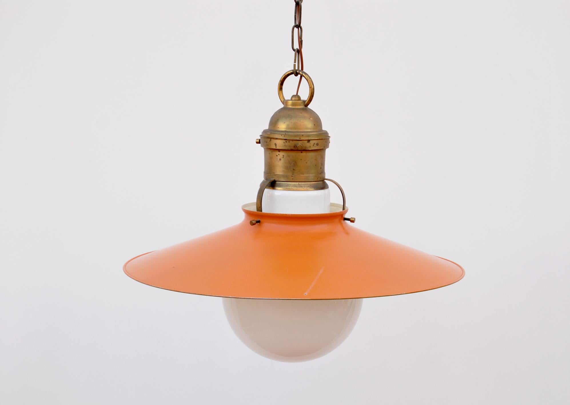Pendant chandelier, 1950s.
Suspension chandelier made of brass and orange-colored iron, with opal glass shade covers (shaped like a light bulb). The electrical system has been rewired. At the top of the dish is a brass accessory containing the lamp