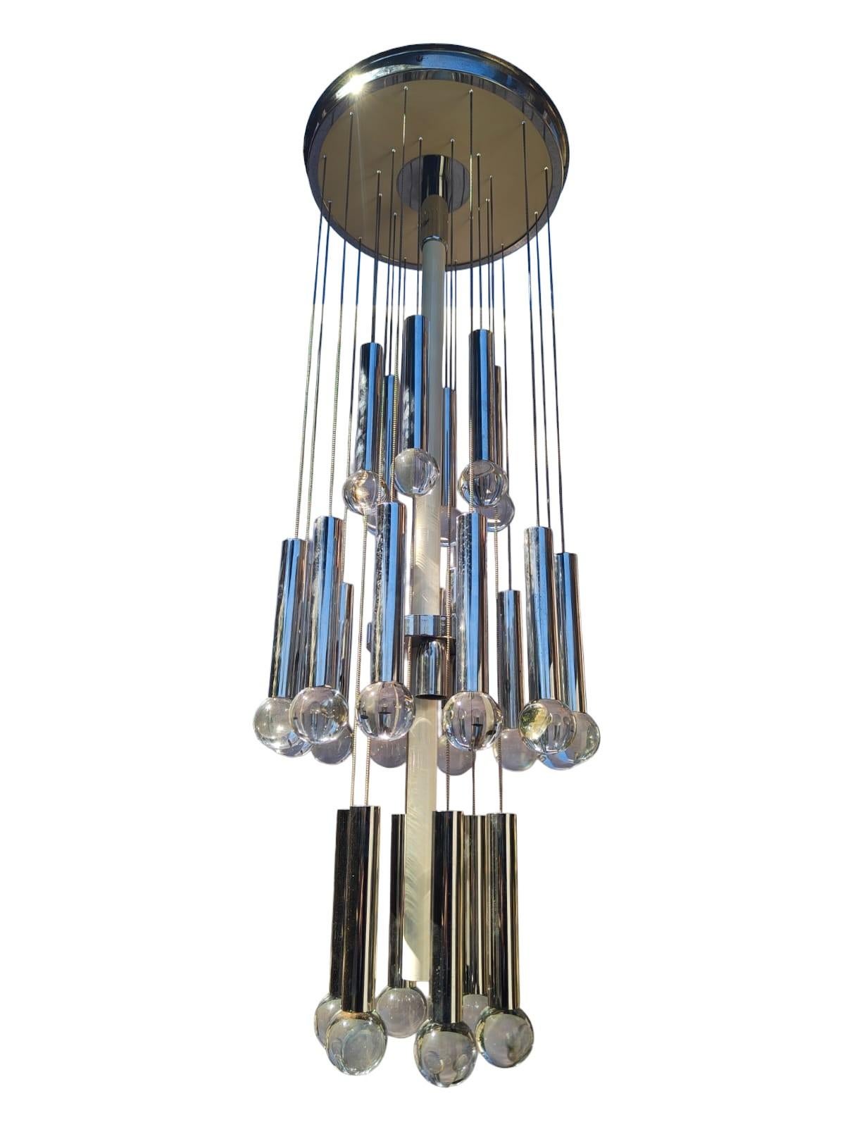 Lampadario a cascata prodotto da Gaetano Sciolari negli anni 70. E' composto da una plafoniera da fissare al soffitto da cui scende un corpo centrale in metallo cromato con otto luci e delle catene terminanti con cilindri e sfere di vetro. 

La sua