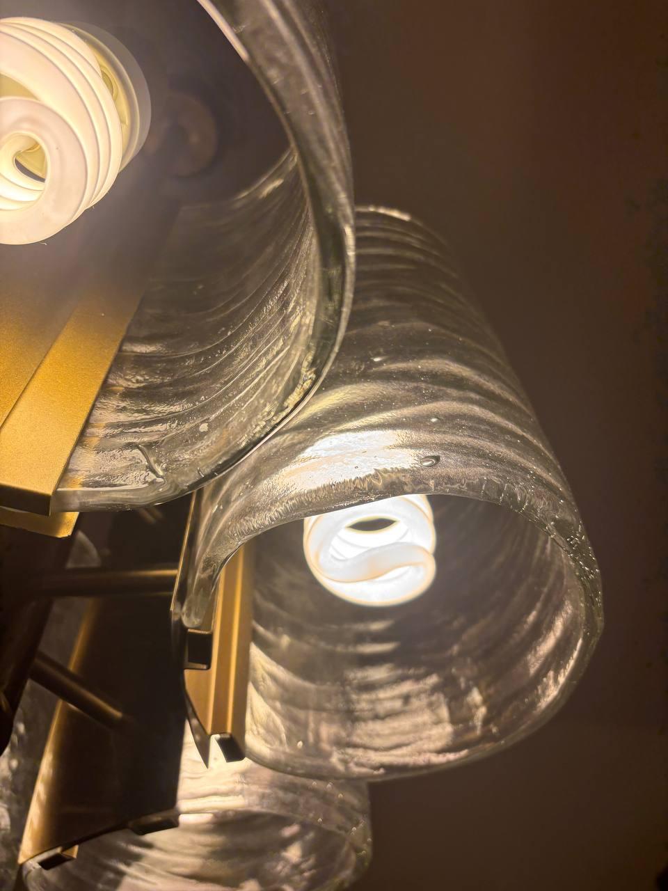 This stunning pendant chandelier, designed by Carlo Nason for Pierre Cardin, is an icon of 1970s Italian design. Its frame, made of brass, features a fine finish that enhances its luster and character.

The chandelier consists of six Murano glass
