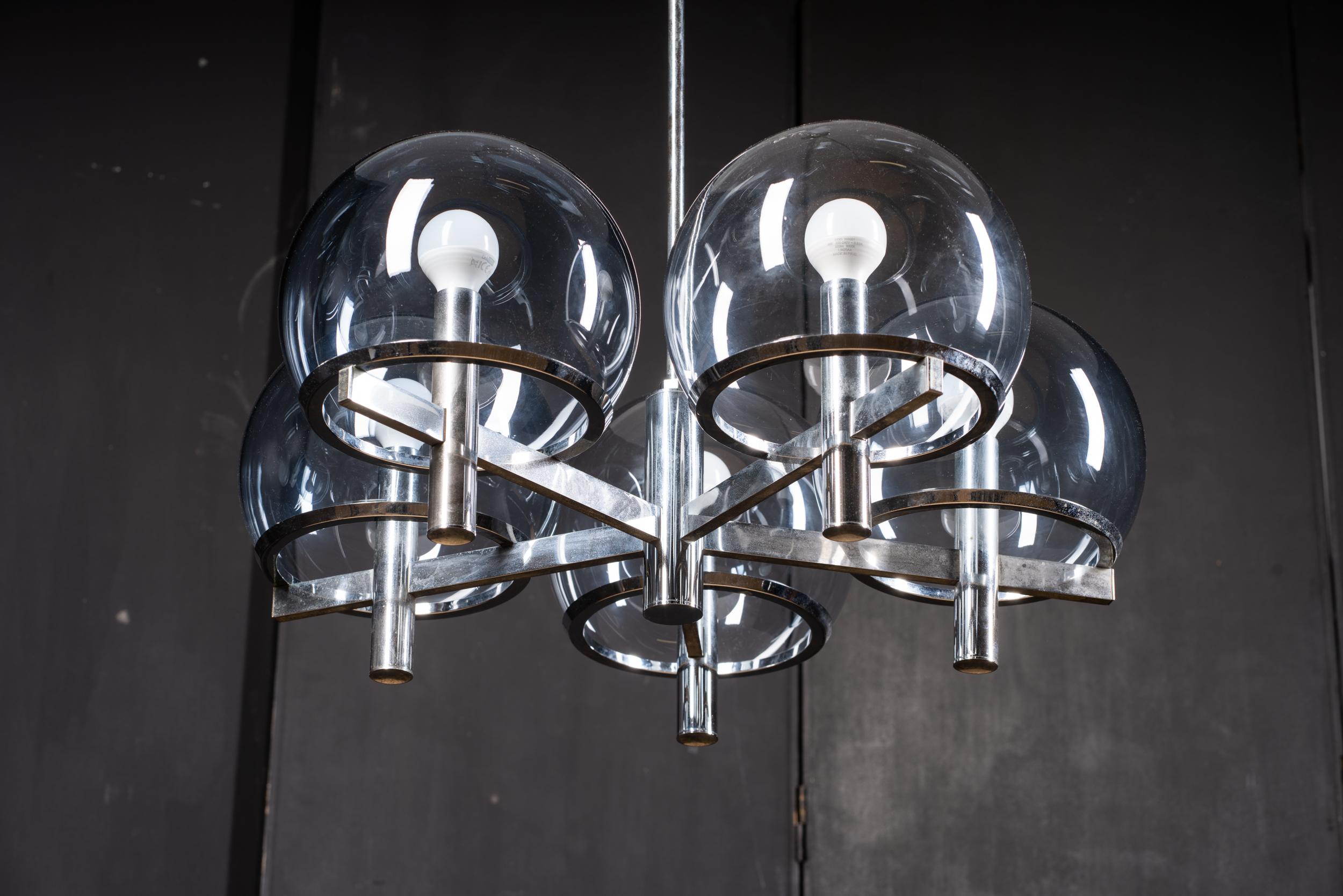 Airer Club Kronleuchter 
Mit fünf verchromten Metallarmen und ebenso vielen transparenten Glasschalen, entworfen und hergestellt von Gaetano Sciolari, ist sie eines der ikonischen Produkte des Unternehmens, das in den 1960er Jahren der erste