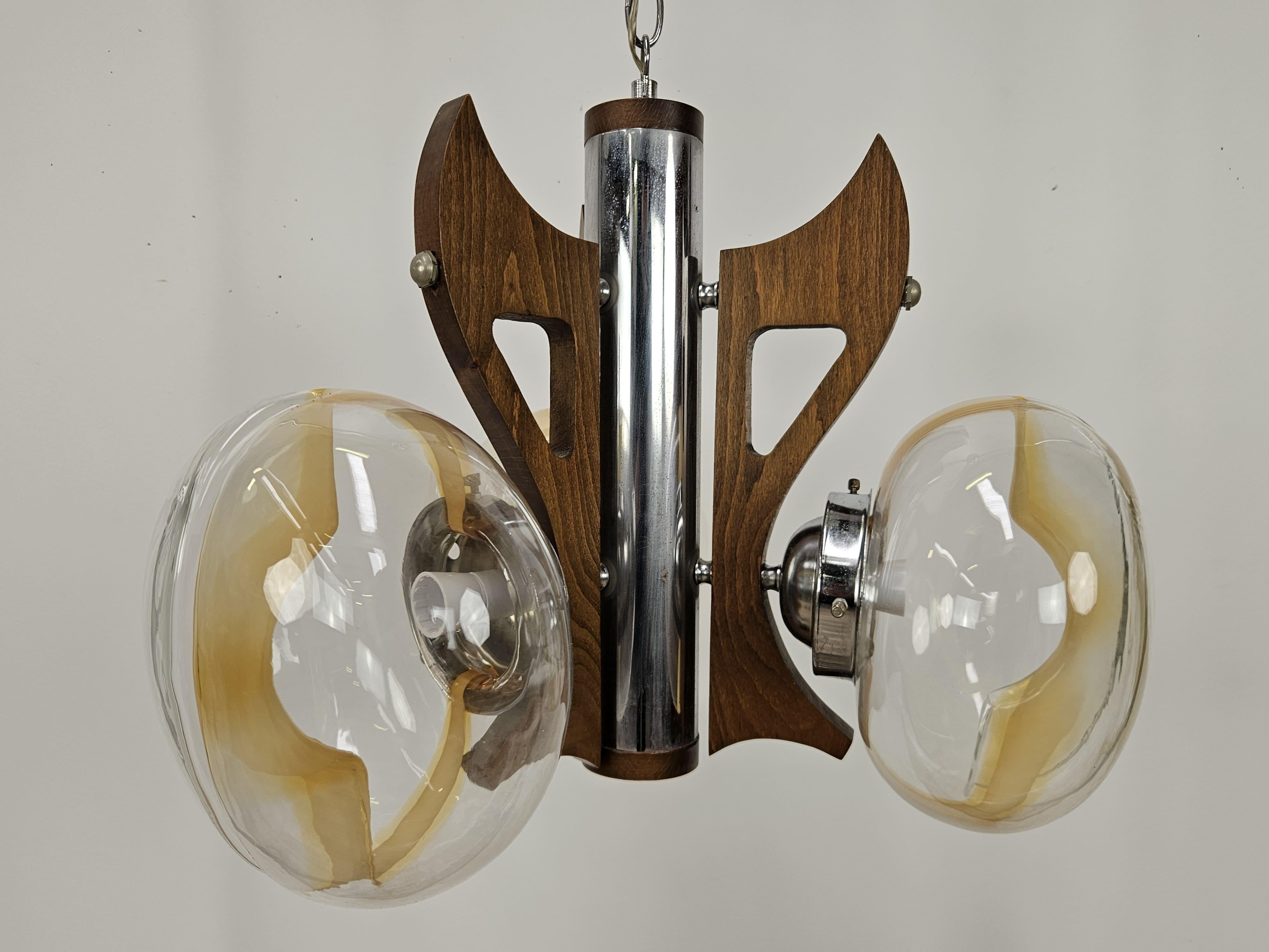 Lampadario italiano anni '60 con struttura in legno e metallo, arricchito da tre plafoniere in vetro trasparente con decori colorati.

Molto particolare, si presta benissimo in ambienti come cucine soggiorni o ingressi.