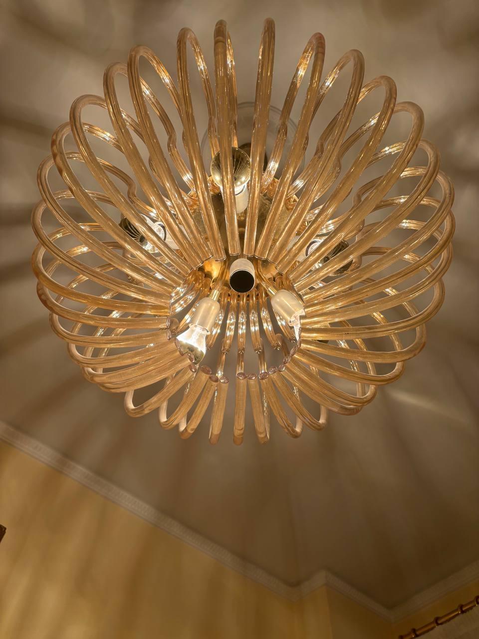 Lampadario italiano Venini di Murano del 1960 con 42 bicchieri in vetro curvi color champagne. Le lampade sono legate alla struttura con 6 tubi di vetro e portalampada in ottone. Contiene sei sorgenti luminose. Condizioni: Eccellenti condizioni