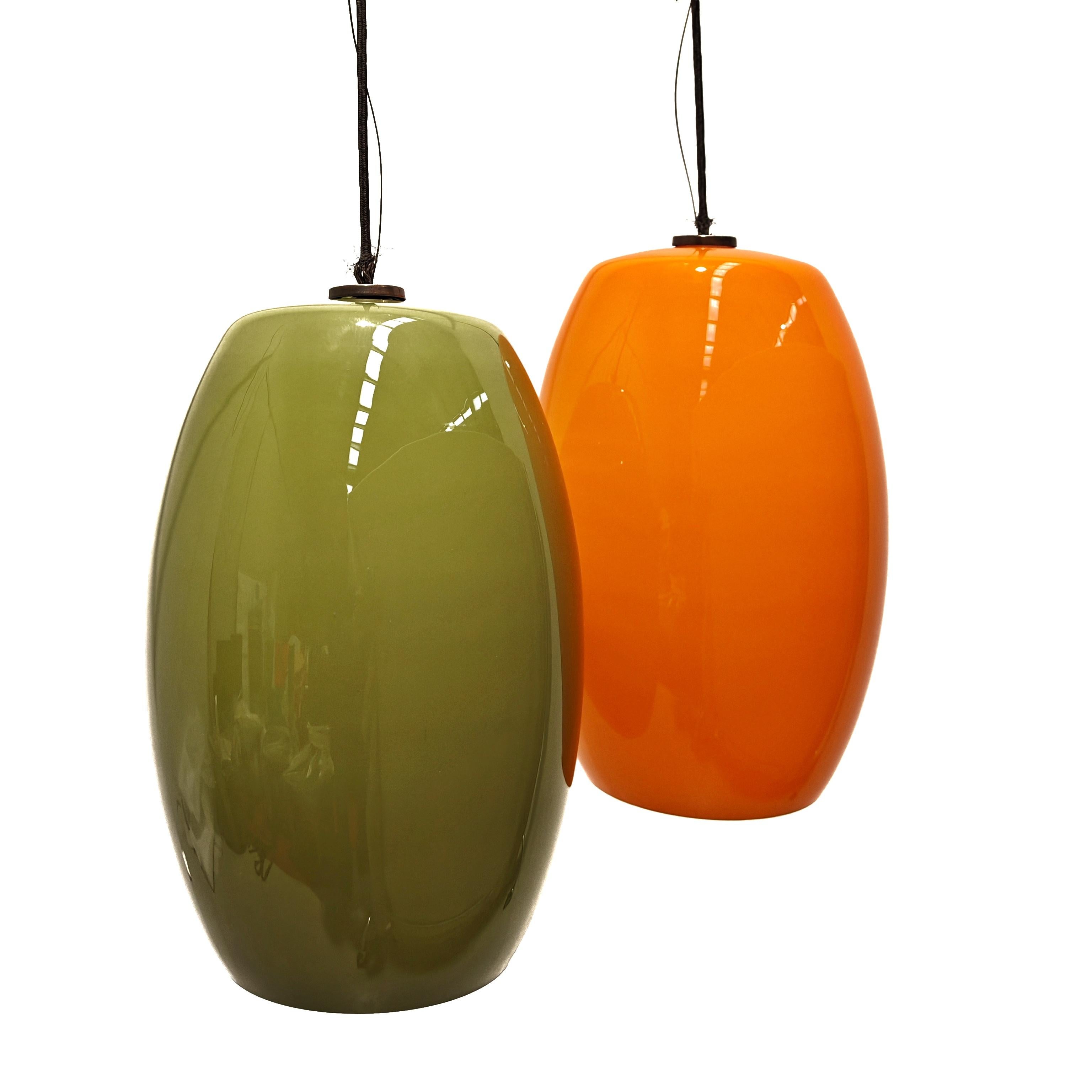 Lampadario con 2 grandi pendenti in vetro di Murano  verde e arancio degli anni 60.
 I 2 pendenti sono vetro soffiato e incamiciato come nelle migliori produzioni delle vetrerie vistosi di quegli anni. 
Sono impreziositi con attacchi dei fili in