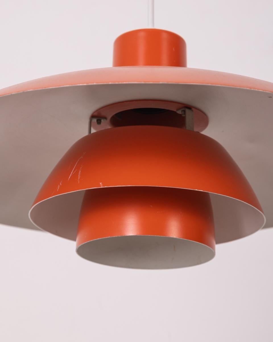 Lámpara de metal naranja, modelo 4/3, diseño de Poul Hanningsen para Louis Poulsen, años 60.

CONDICIONES: En buen estado, funcional, presenta huellas de uso temporales y visibles en foto.

DIMENSIONES: Altura 19 cm; Diámetro 42 cm

MATERIALI: