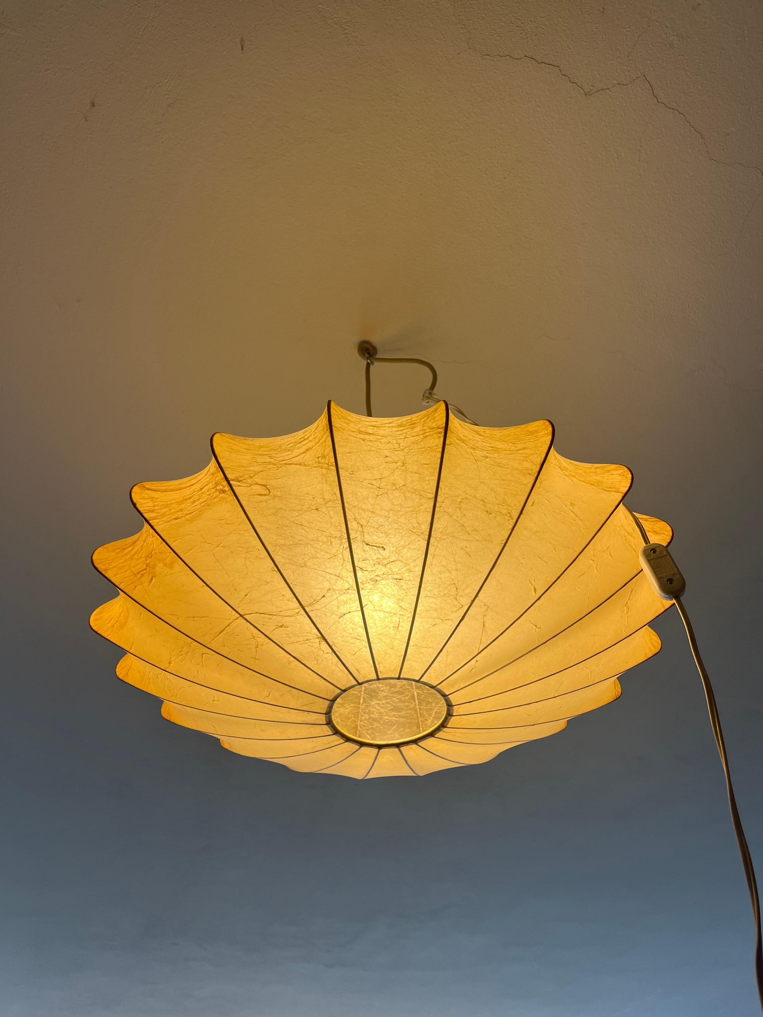 Elegant ceiling chandelier from the 1960s, an authentic design piece signed by the famous George Nelson. This chandelier, made of cocoon resin, represents an innovative material for the time, giving the piece a unique and sophisticated look. Its