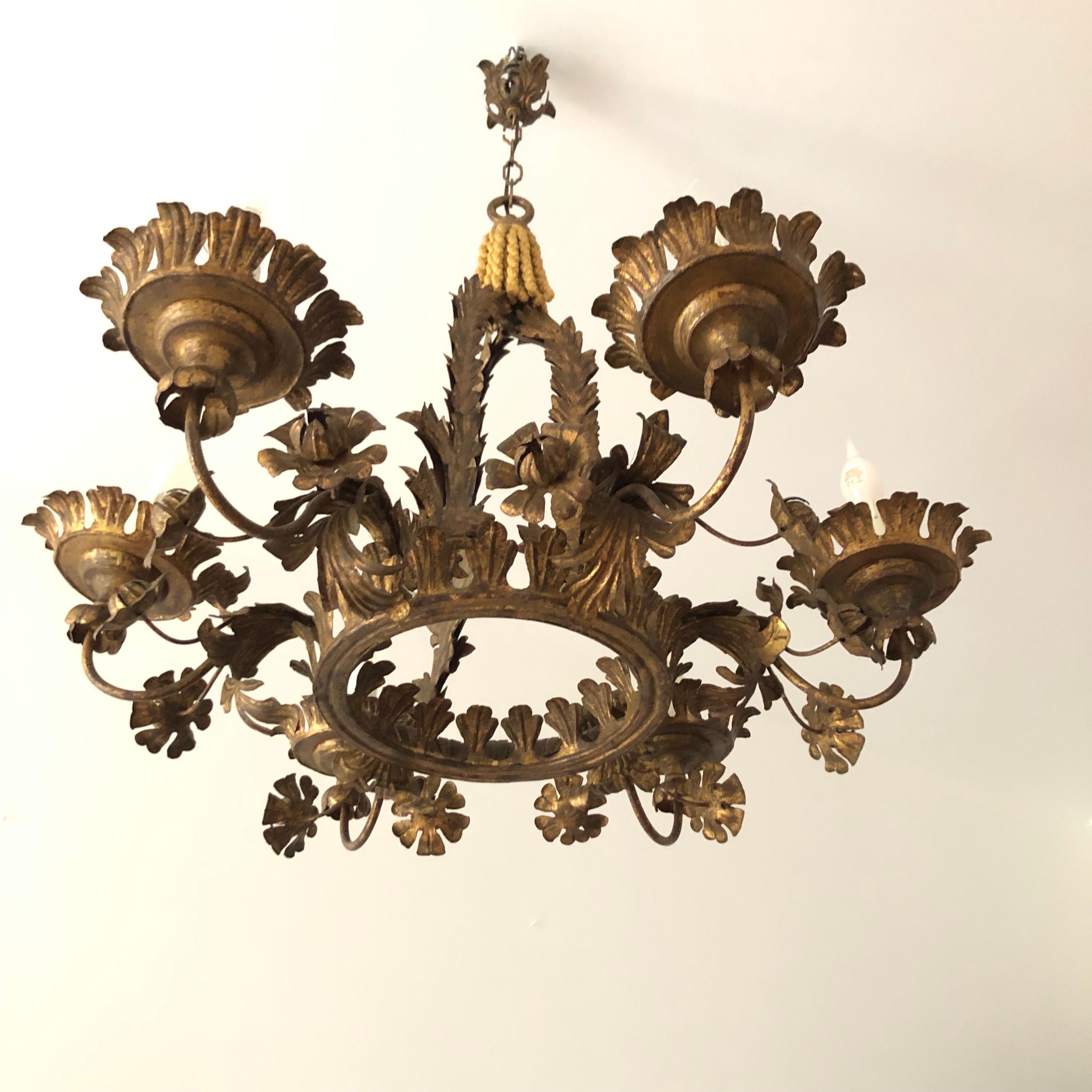 Antico lampadario fiorentino fogliato con decorazioni floreali  realizzato alla fine del XIX secolo in ferro dorato e sei luci.  Lampadario d'epoca italiano, di forma circolare  caratterizzato da un design riccamente decorato con foglie e fiori e