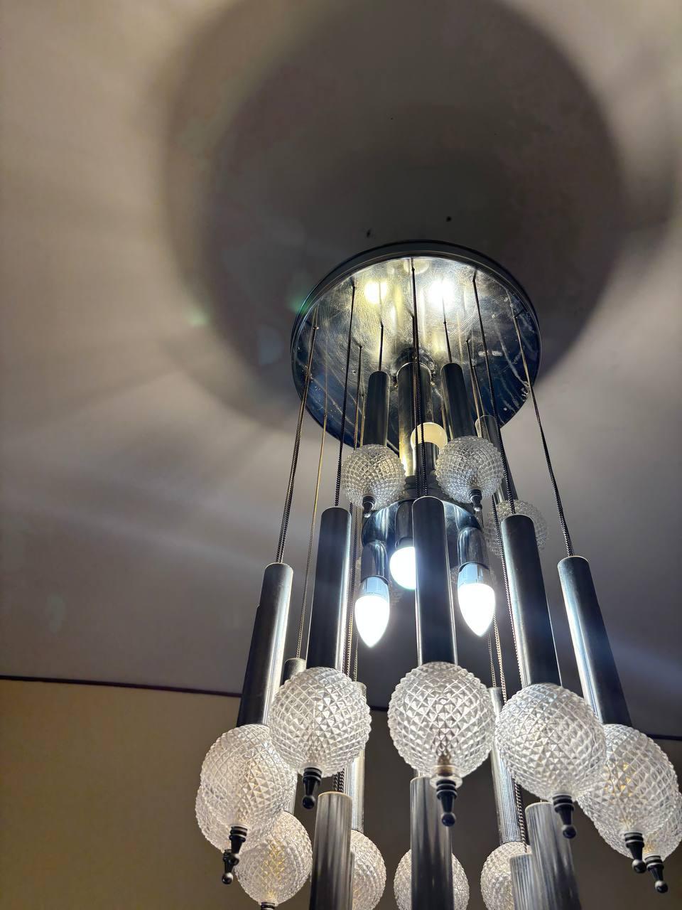 Lámpara de suspensión diseñada por Gaetano Sciolari en la década de 1970.
Estructura en cascada con tallos y cadenas de metal cromado y 24 cuencos de cristal moleteado.
Para 8 bombillas con casquillo E14
Altura 92 cm
Diámetro 40 cm
Muy buen estado