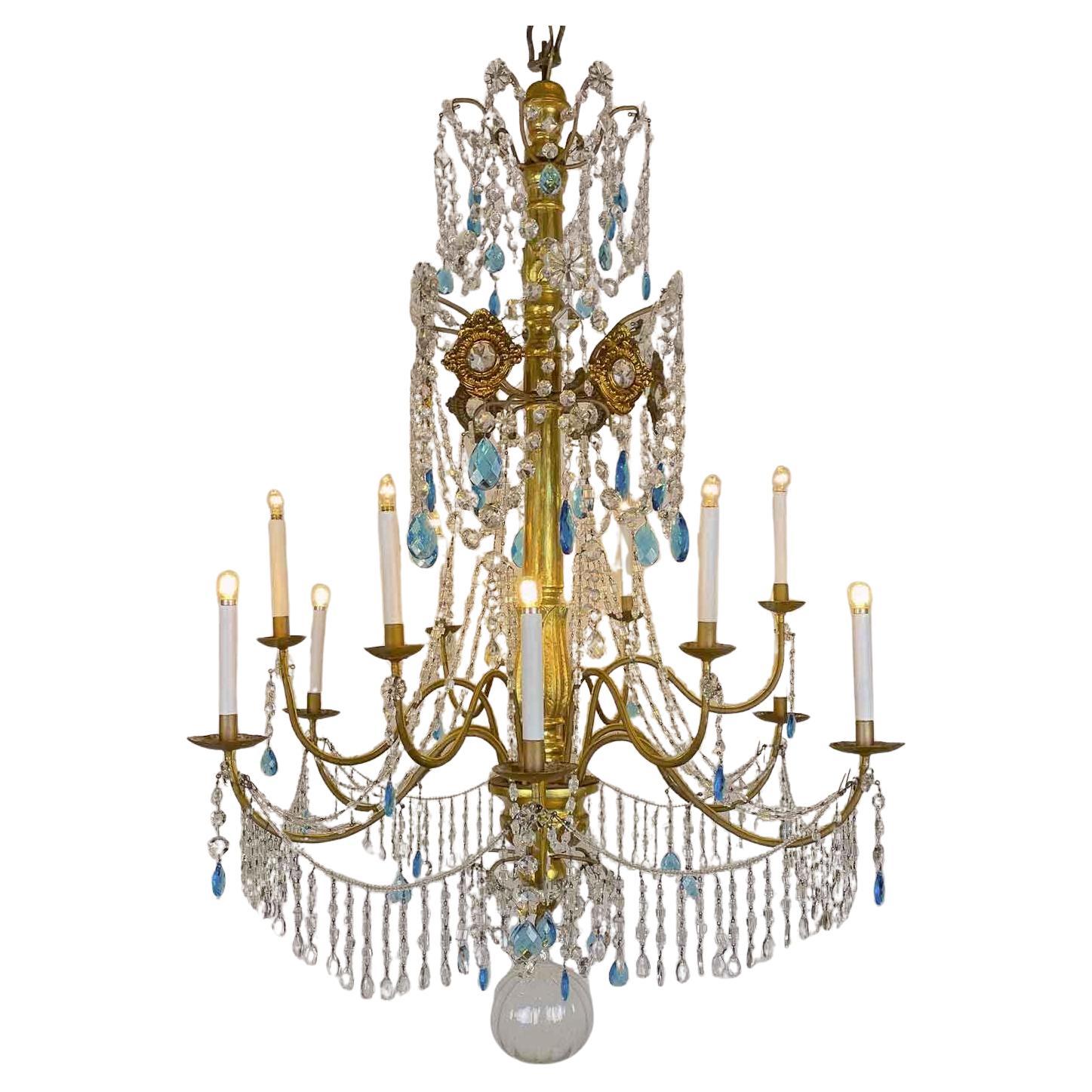 Extraordinary Genovese Chandelier circa 1780 with Twelve Lights with transparent and blue crystals. Large Empire chandelier in Sculpted and Gilded Wood from the late 18th century, like the chandeliers in the Ducal Palace in Genoa. It consists of a