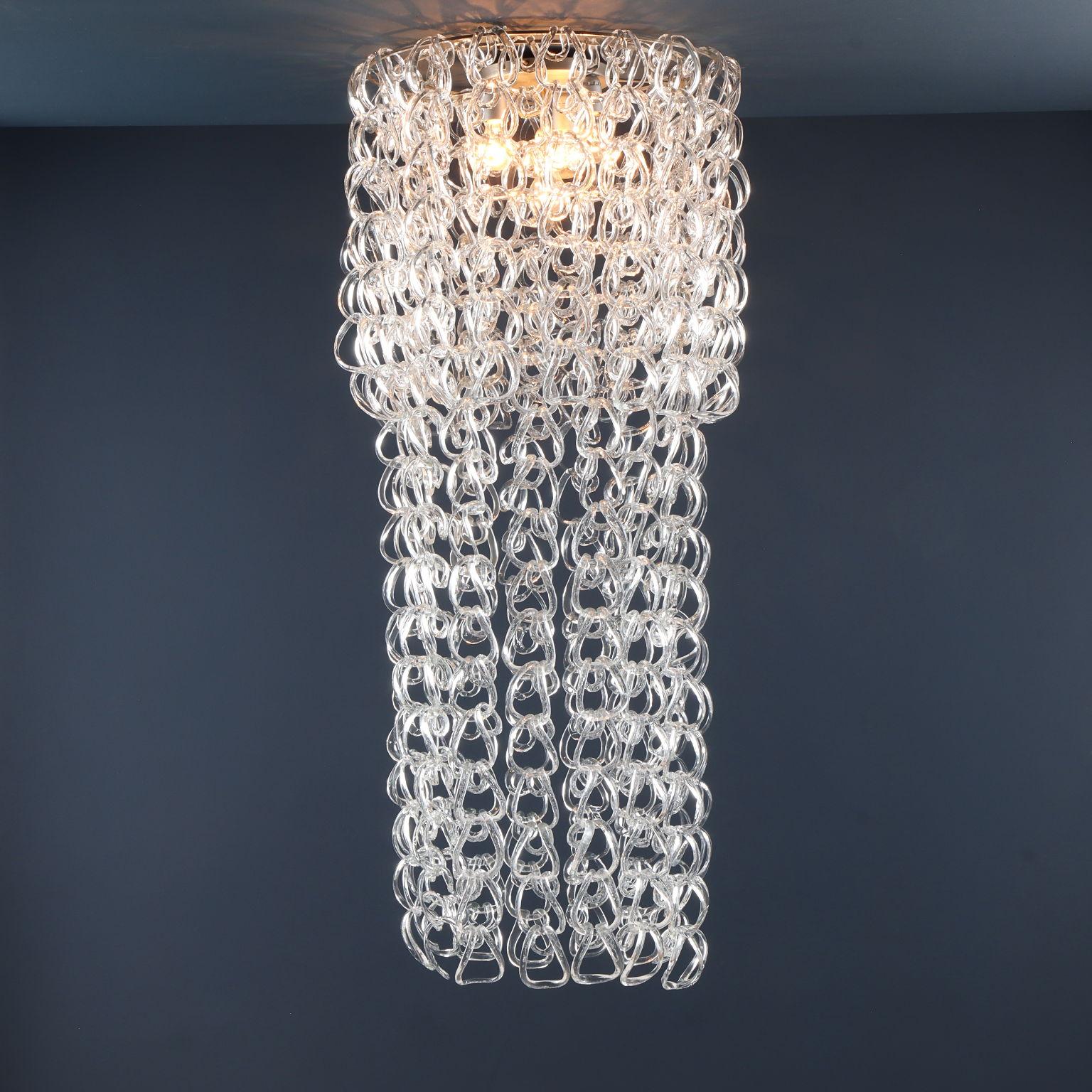 Scenic chandelier from the 'Giogali' series with about four hundred transparent Murano glass pieces woven on a double chrome-plated metal frame.
Design by Angelo Mangiarotti for a late 1960s Vistosi production.