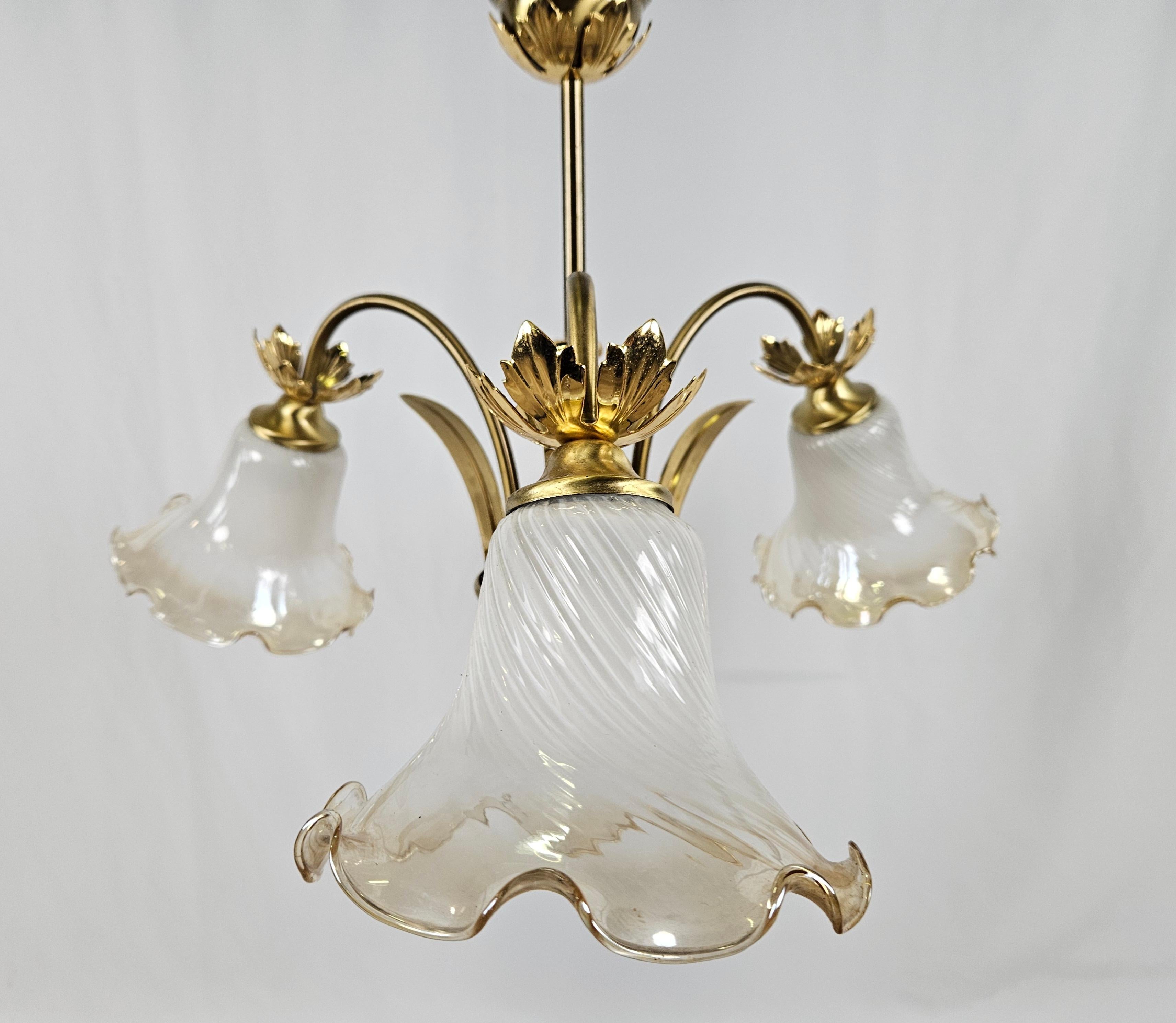 1970s ceiling chandelier designed and planned reminiscent of Art Nouveau and Art Nouveau style, ideal for rooms with antique or modern decor.

It has three light points with machined glass ceiling lights, also features several brass structural