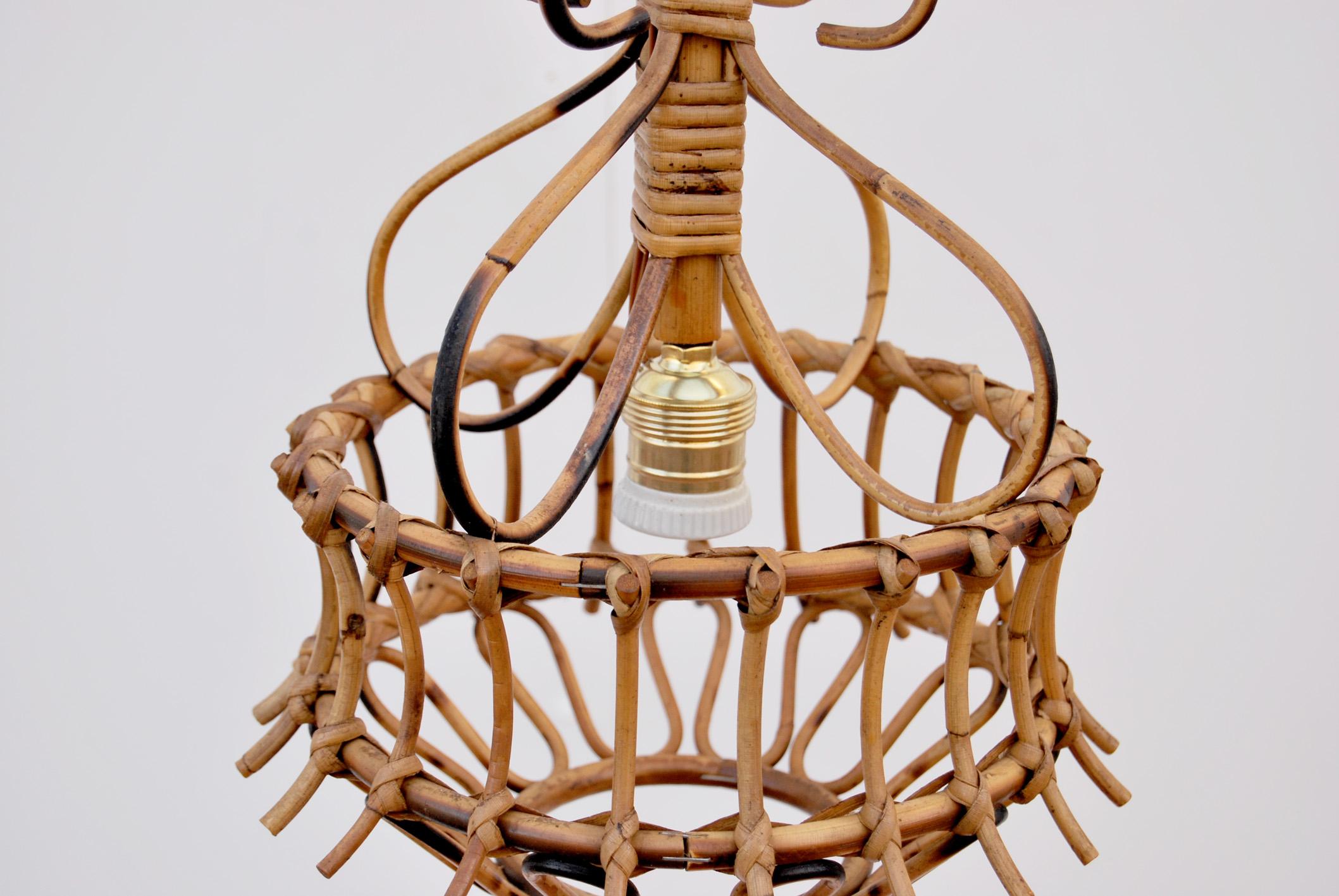 Lampadario in bambu' e vimini, Anni '60, Made in Italy. 
Il lampadario è composto da un paralume in bambu' lavorato a mano, e la catena è composta da maglie rotonde in rattan, che possono essere regolate in altezza. Il lampadario è stato ricablato e