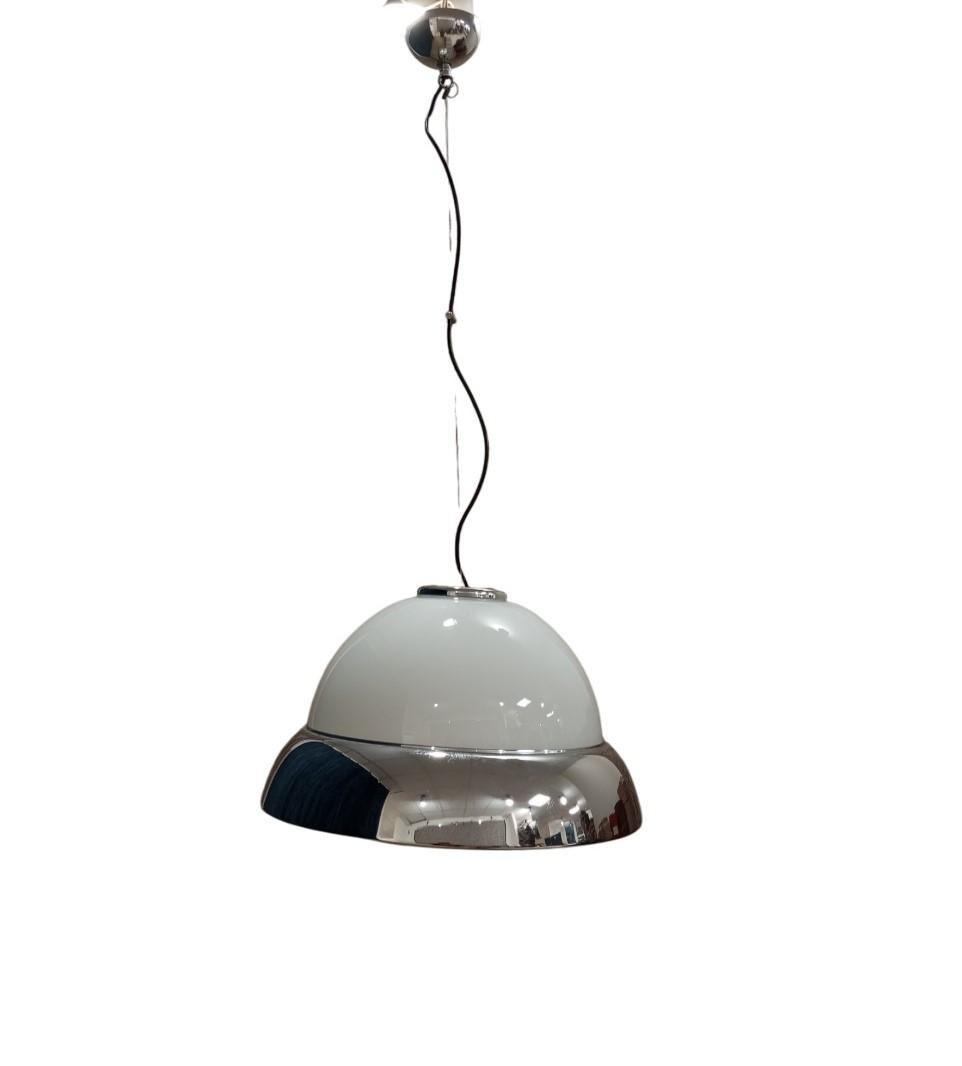 Lampada a sospensione in vetro opalino bianco con diffusore in metallo cromato, dal design vintage. Con un diametro di 50 cm. ed h di 30 cm. Ha una forma a cupola con una parte superiore in vetro bianco opaco e una parte inferiore con una finitura