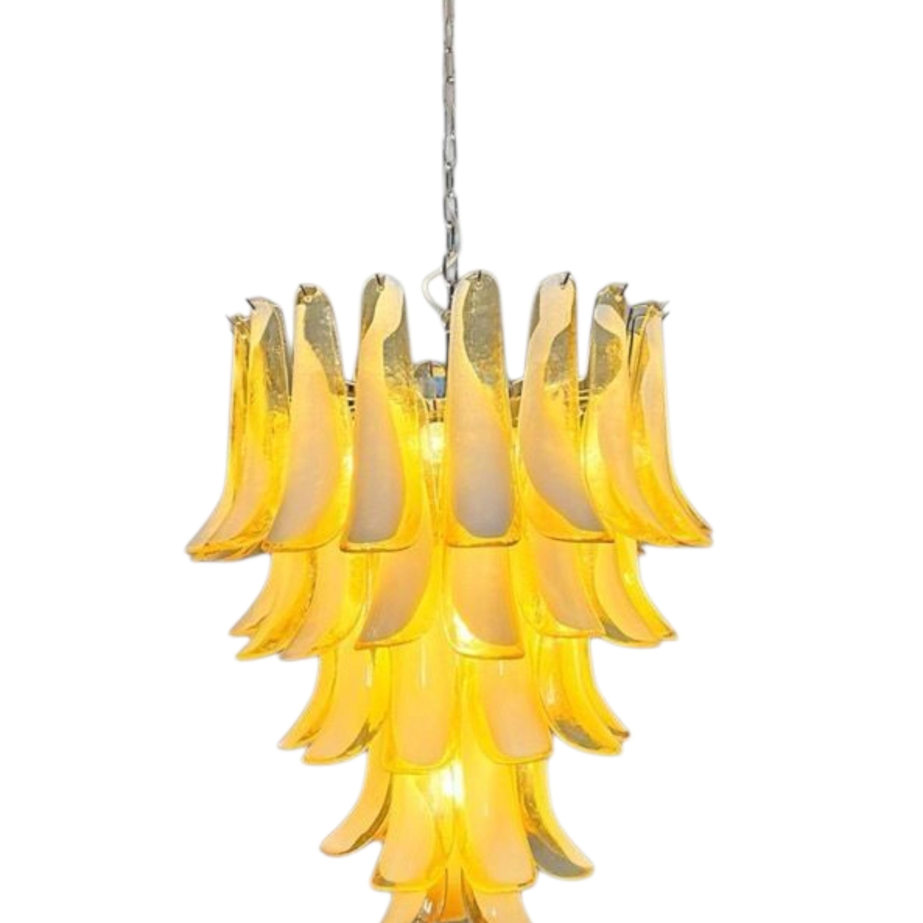 Dieser bernsteinfarbene Murano-Kronleuchter, der wie eine Kaskade aus goldenem Licht schwebt, ist das Ergebnis einer Begegnung zwischen Handwerkskunst und der Poesie des Lichts. Jedes Element erzählt eine uralte Geschichte, die sich aus geschickten