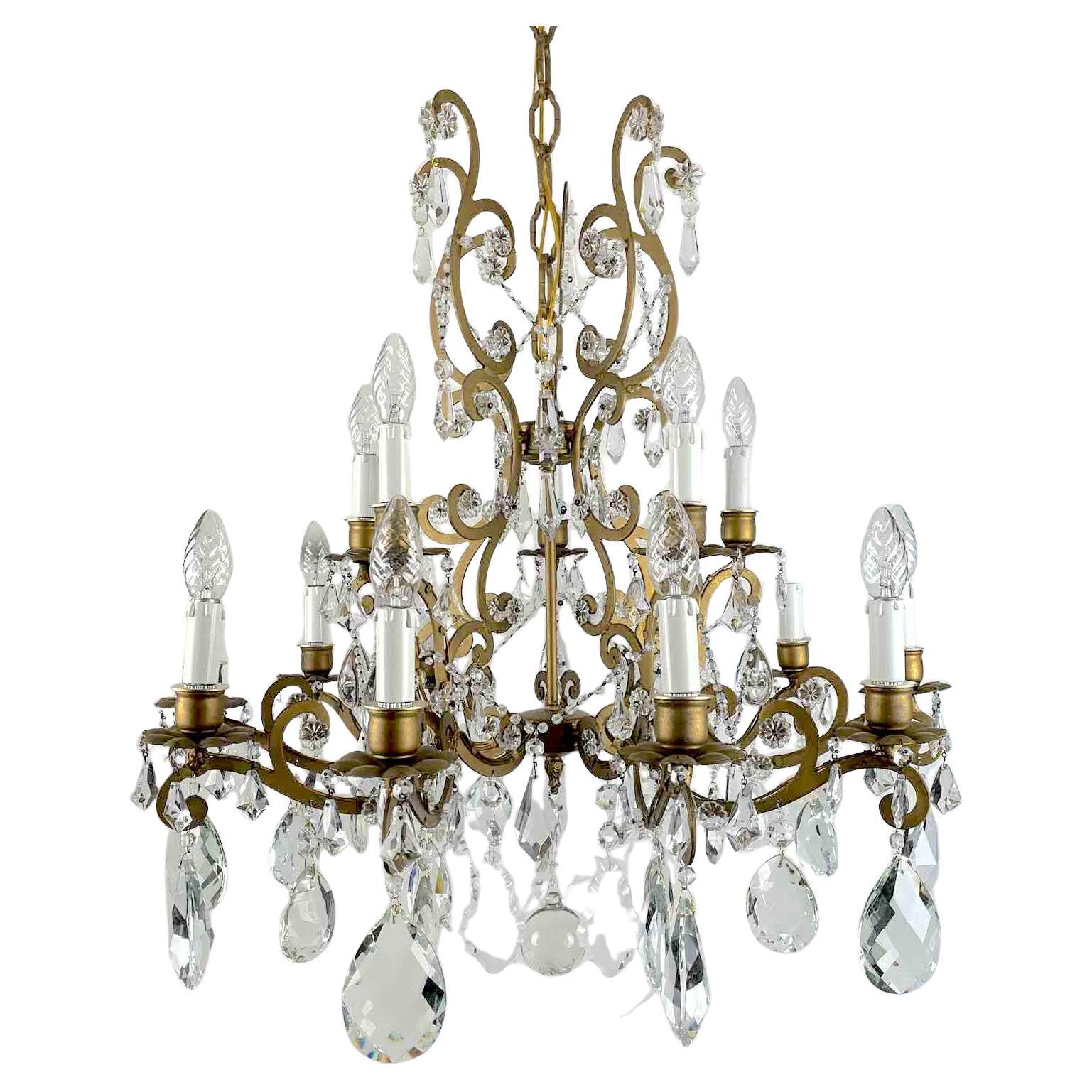 Gilded Iron And Crystal Chandelier 15 lights on two tiers high, ten lower arms plus five lights arranged at the top, curved arms with double scrollwork, dates from the 1950s and is in perfect condition, ready to hang. The circular structure is