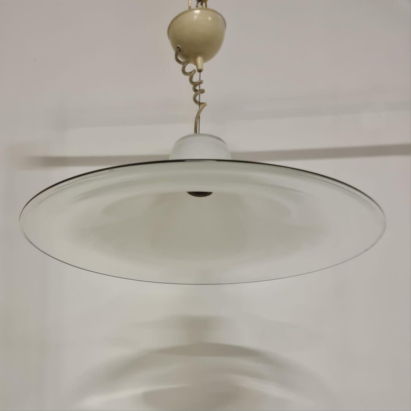 Lampadario di Renato Toso per Leucos.

Elegante lampadario anni 70'.

In vetro di murano che passa gradualmente dal bianco opalino al trasparente con bordatura nera.

Disegnato da Renato Toso, designer e architetto Muranese di nascita. Figlio d'arte