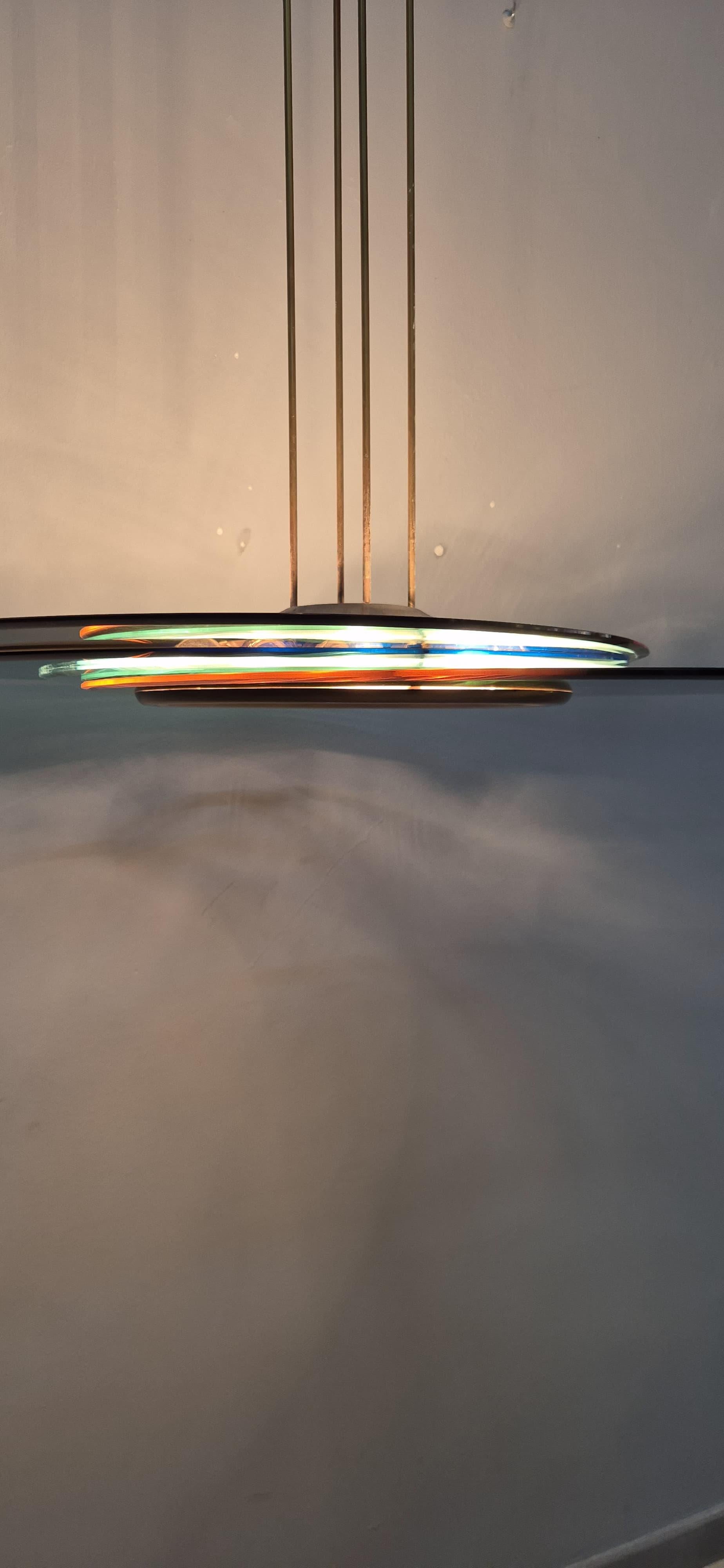Esta extraordinaria araña de Max Ingrand para Fontana Arte es una obra maestra del diseño y la innovación, un símbolo de la elegancia y la sofisticación de la iluminación italiana de los años sesenta. Max Ingrand, reputado diseñador y maestro