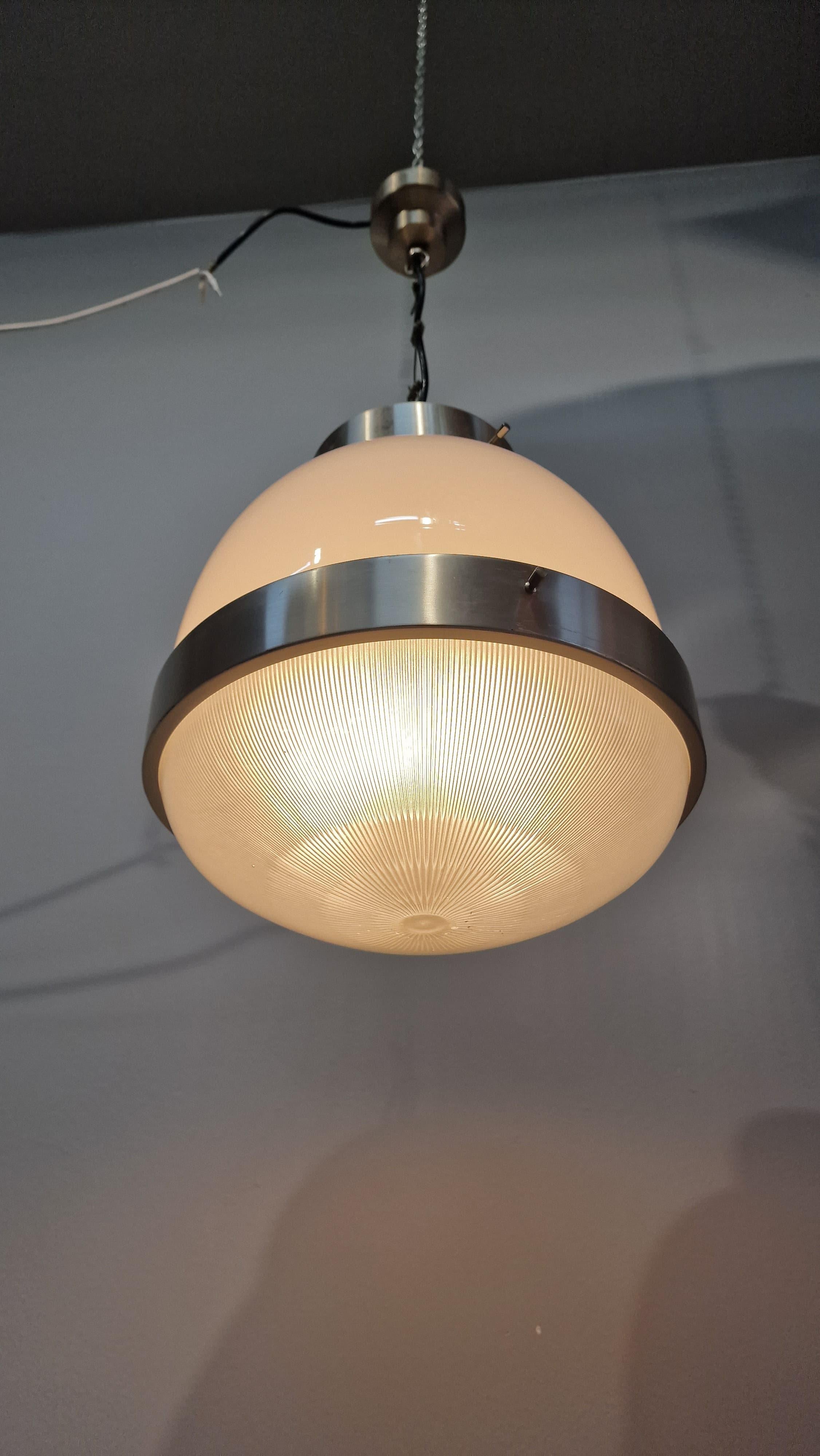 Preciosa lámpara de Sergio Mazza, diseñada para Artemide. La araña tiene una estructura de latón niquelado y una pantalla de cristal opalino que proporciona a la habitación una elegante luz suave.
La araña está en excelentes condiciones como se