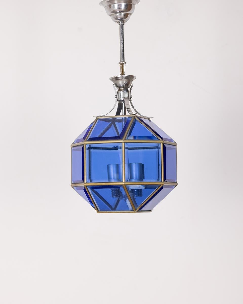 Lampadario con struttura in metallo cromato e vetri blu molati, design Italiano, anni 60.

CONDIZIONI: In buone condizioni, funzionante, presenta segni d'usura dati dal tempo e visibili in foto.

DIMENSIONI: Altezza 47 cm; Diametro 22 cm

MATERIALI: