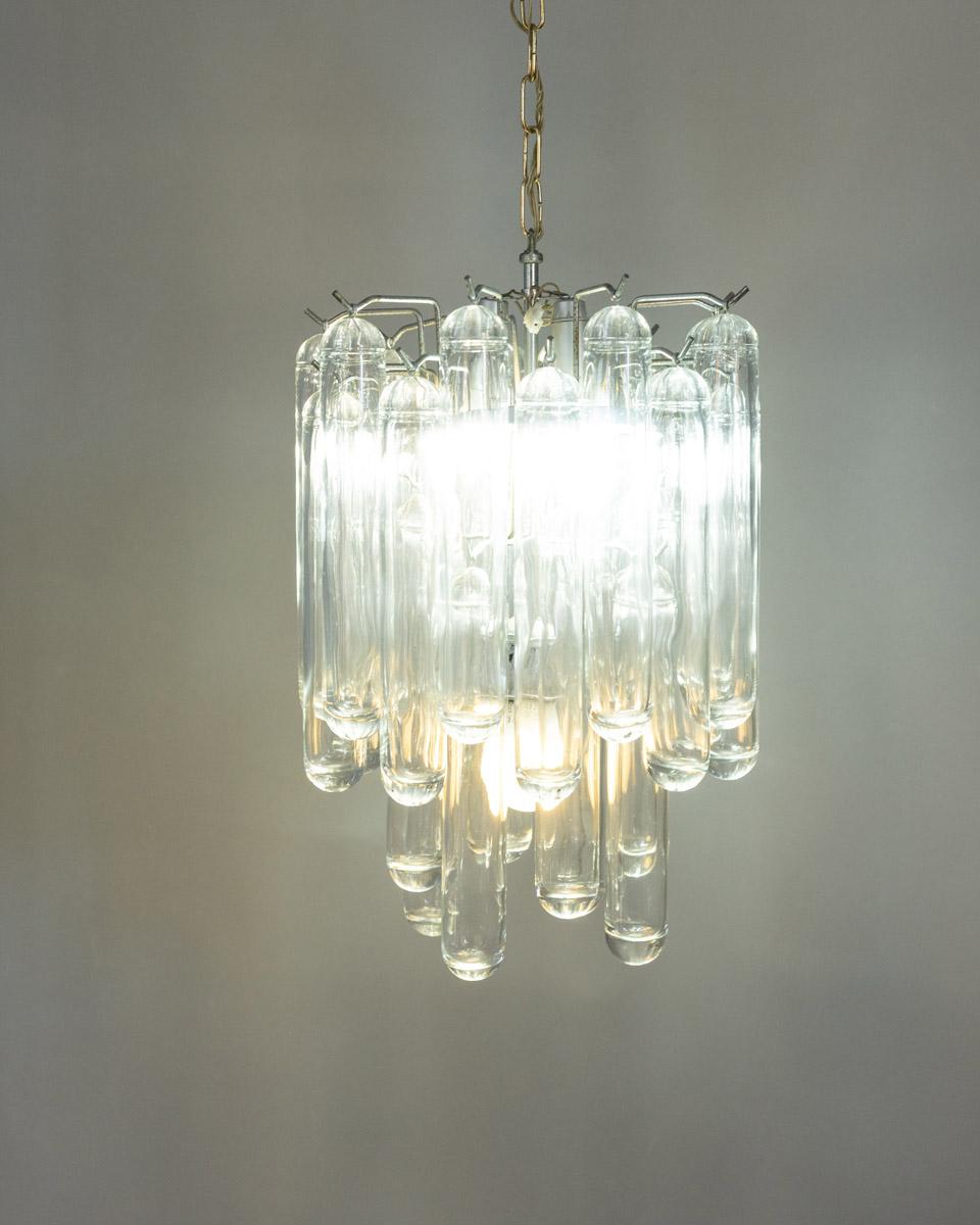Chandelier with chrome-plated steel frame and tubular pendants in transparent murano glass, design Gaetano Sciolari for Sciolari, 1960s.

CONDITION:
In good, working condition, may show signs of wear given by time.

SIZING: 
Height 70 cm; Diameter