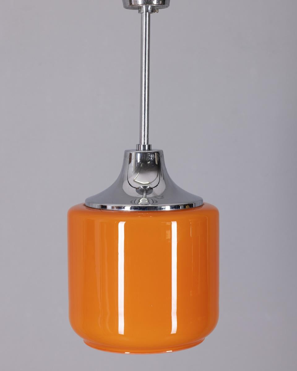 Lampada a sospensione in metallo cromato con paralume in vetro opalino arancio, design italiano, anni '70.

CONDIZIONE:
In buone condizioni, funzionante, può presentare segni di usura dovuti all'età.

DIMENSIONI:
Altezza 45 cm; Diametro 19