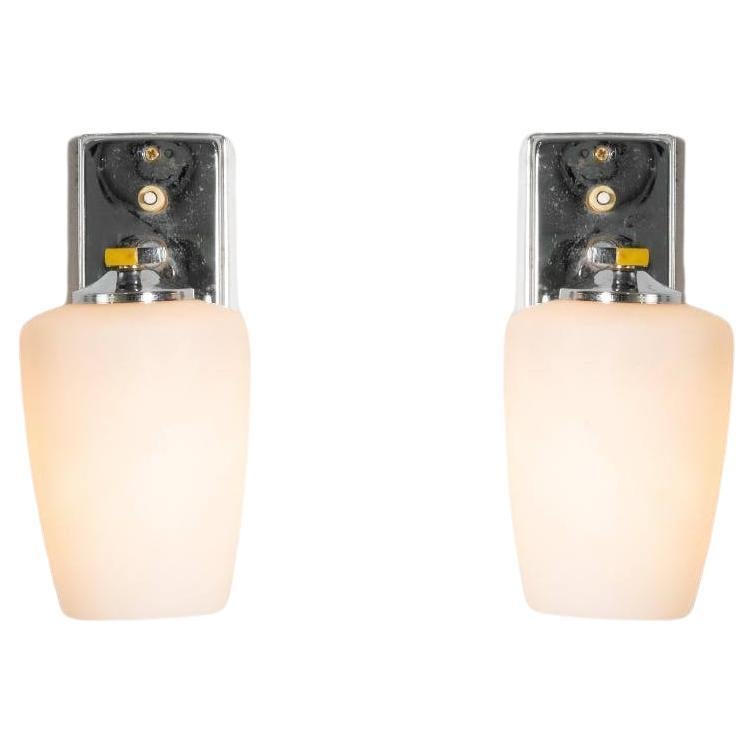 Wandlampen, die mit einer Taste leuchten, für eine einzelne Leuchte. Zwei wirklich elegante Lampen, die dank ihres Opalglases so raffiniert sind, dass sie den Stil von Fontana Arte widerspiegeln. Opalglas, das durch die Feder im Rahmen