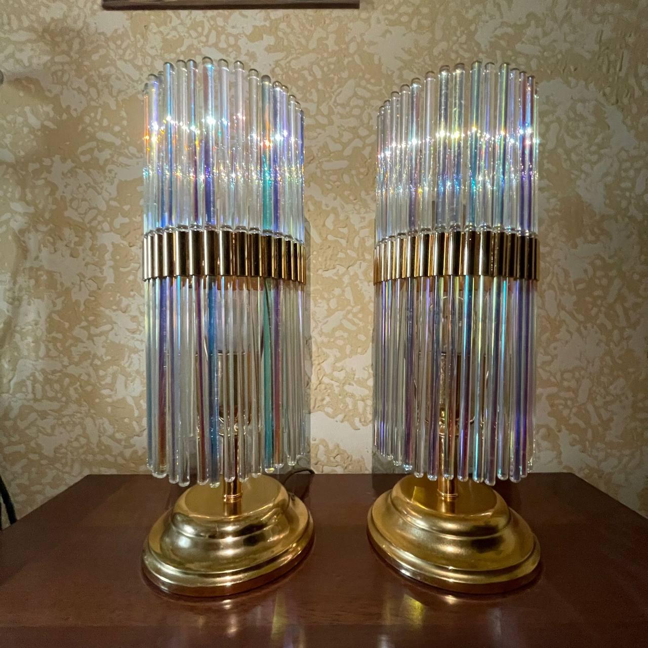 These iridescent lamps, designed by Gaetano Sciolari in the 1960s-70s, embody the elegance and boldness of the design of the time. Featuring a structure composed of thin metal tubes with an iridescent finish, they create a striking play of light and