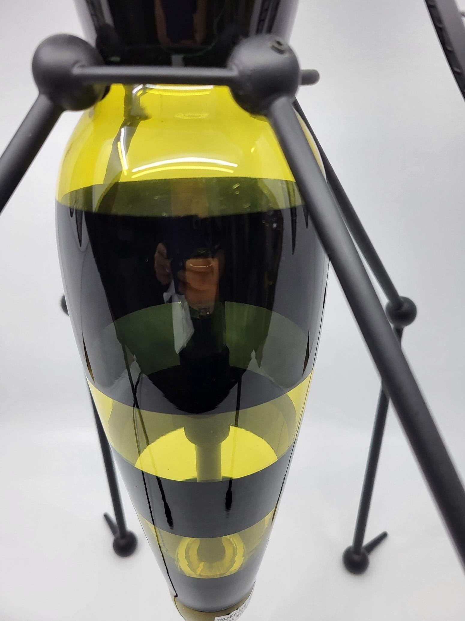 Cette lampe, créée par le designer Vincent Darré pour une série capsule dédiée à Monoprix, lancée en 2021, est une édition limitée. Ce luminaire surprenant capte presque tous les regards. Il est impossible de ne pas remarquer cette lampe en forme