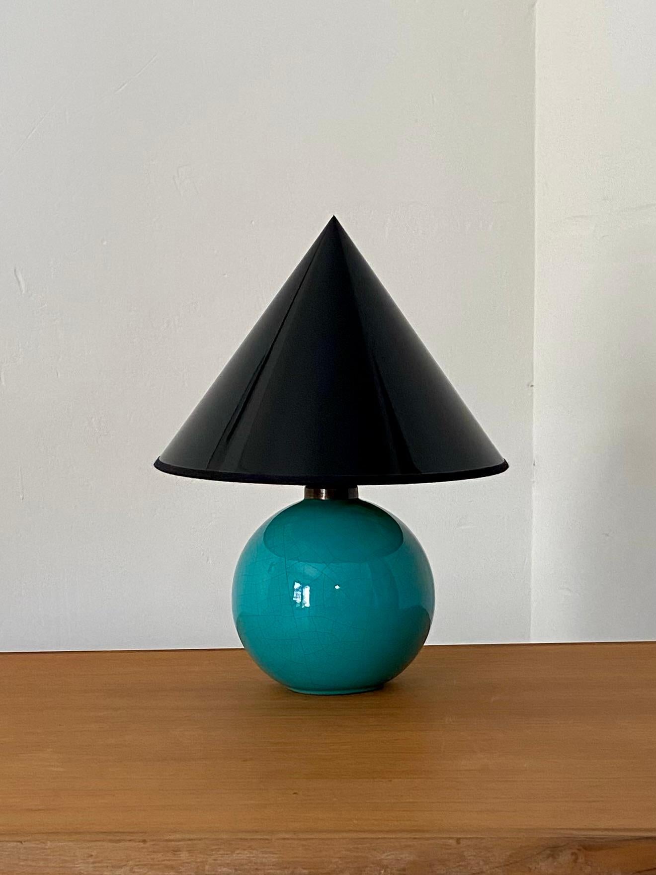 Lampe de table en céramique craquelée turquoise ,style Saint Clément,  coiffée d'un abat-jour pointu en polyphane brillant noir intérieur or. 

La lampe seule mesure 16 centimètres de diamètre 
La base de l'abat-jour mesure 26 centimètres de