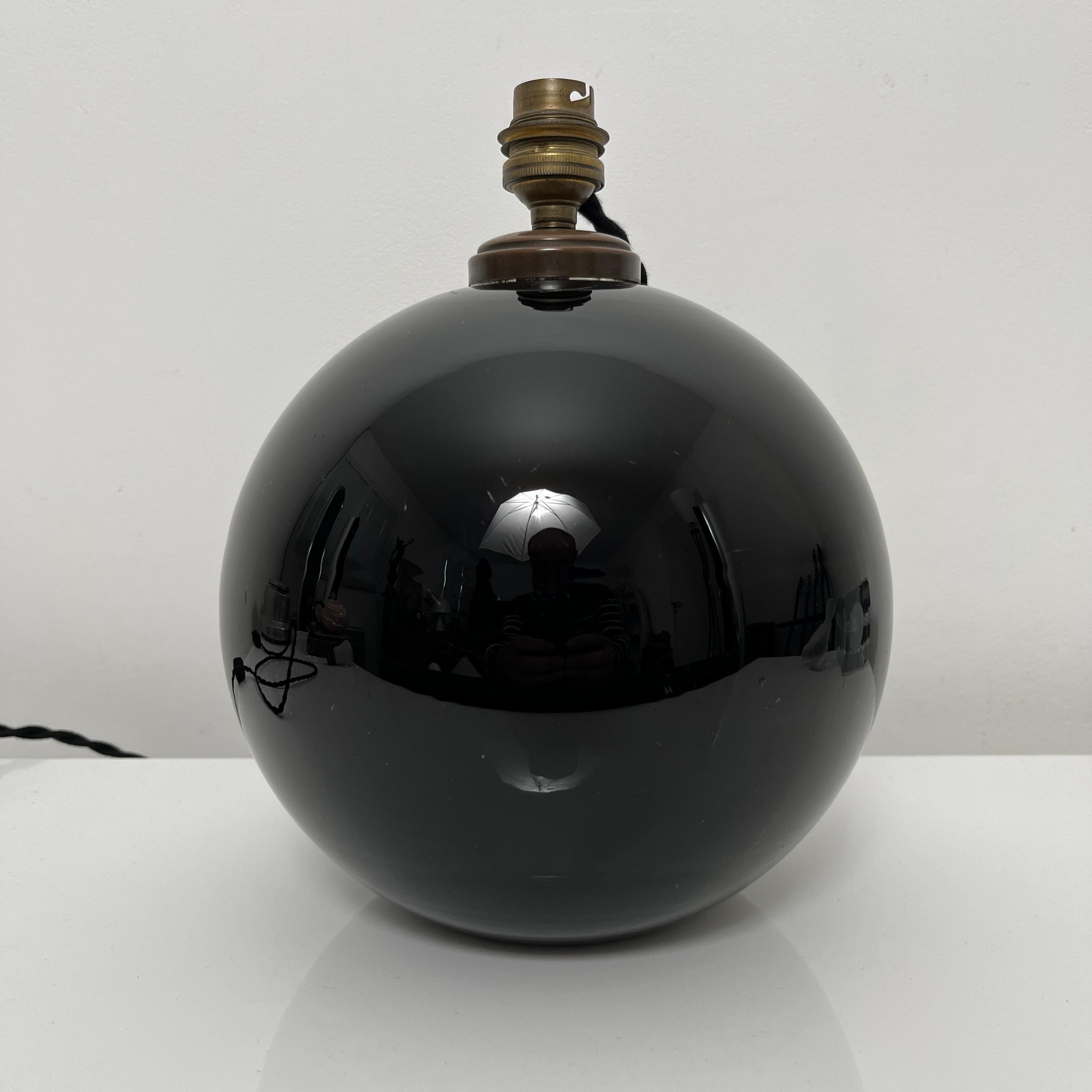 Pied de lampe sphérique en opaline noire de style et d'époque Art Deco. A rapprocher du travail de Jacques Adnet, célèbre décorateur français. 

L'exemplaire proposé à la vente est en état d'usage et présente quelques rayures d'usage visibles sur