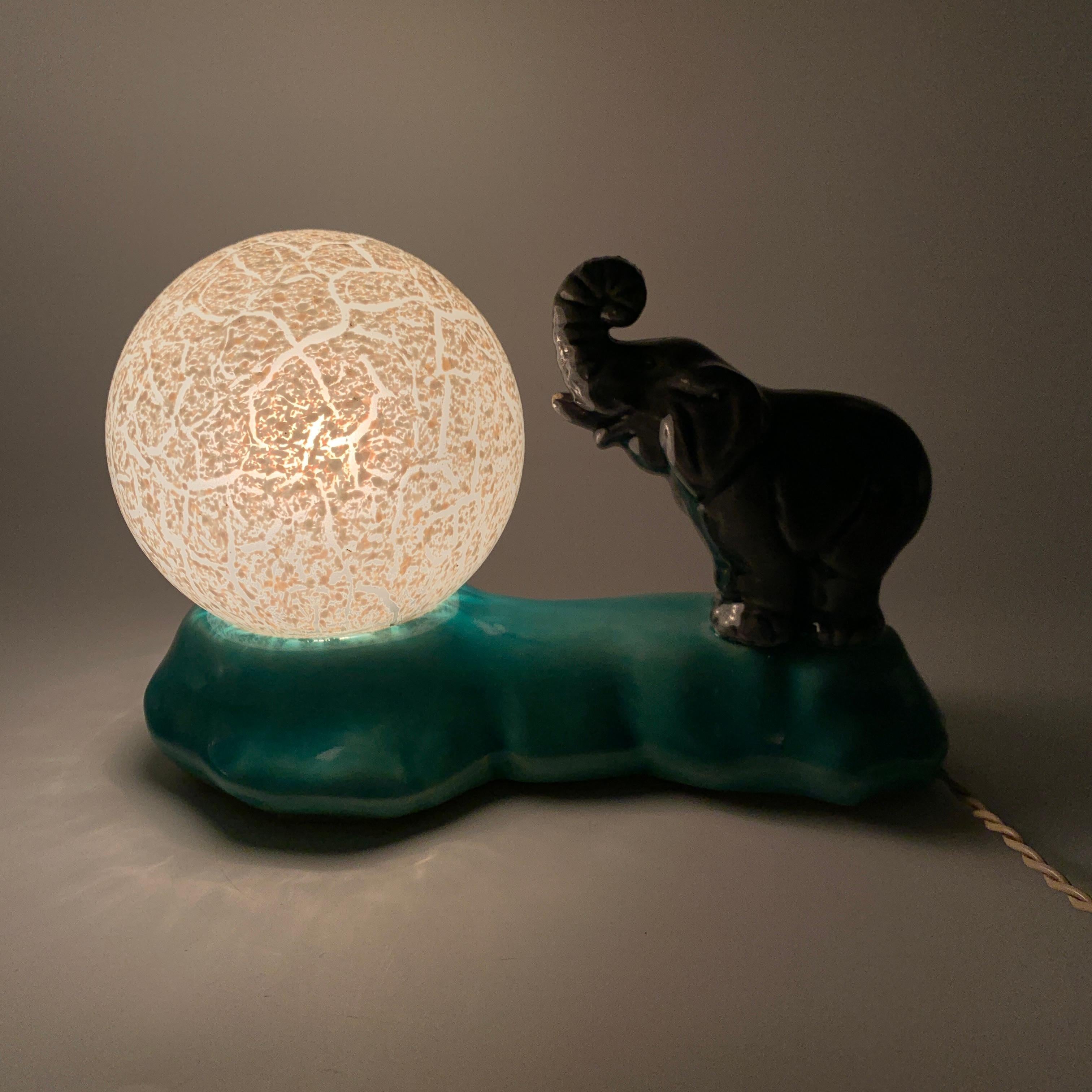 Description : 
Superbe lampe de chevet de style et d’epoque Art Déco en céramique representant un éléphant et son ballon. 

Dimensions : 
Hauteur : 13 cms
Largeur : 20,5 cms
Profondeur : 12 cms

Etat : 
Bon état. A signaler deux minuscules