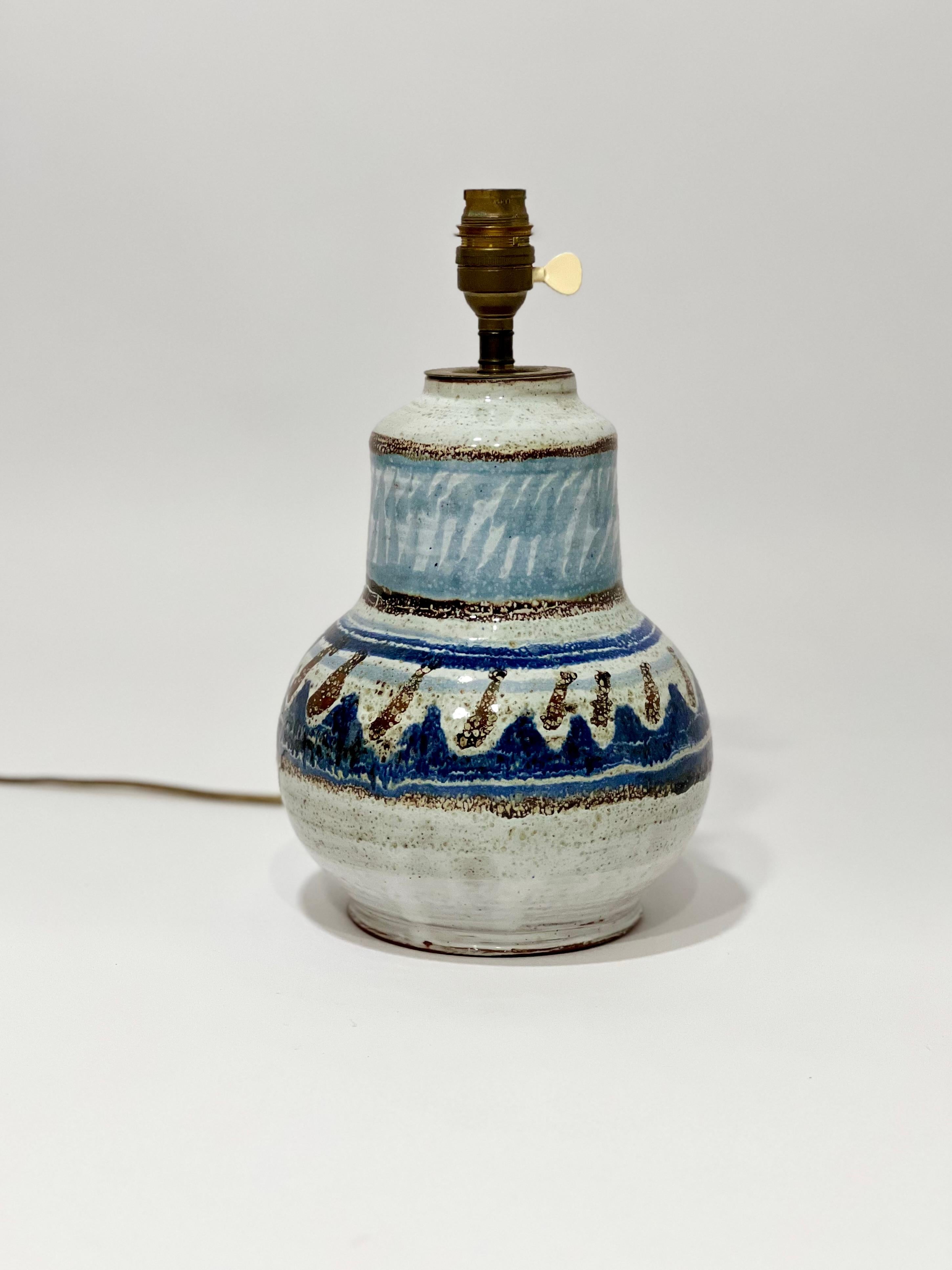 Rare lampe en céramique des années 1970. Céramique peinte et émaillée dans les tons de bleus et blanc avec motifs décoratifs. Céramique signée de l'oiseau stylisé caractéristique Michel Barbier, visible sur le dessous de la céramique. Michel Barbier