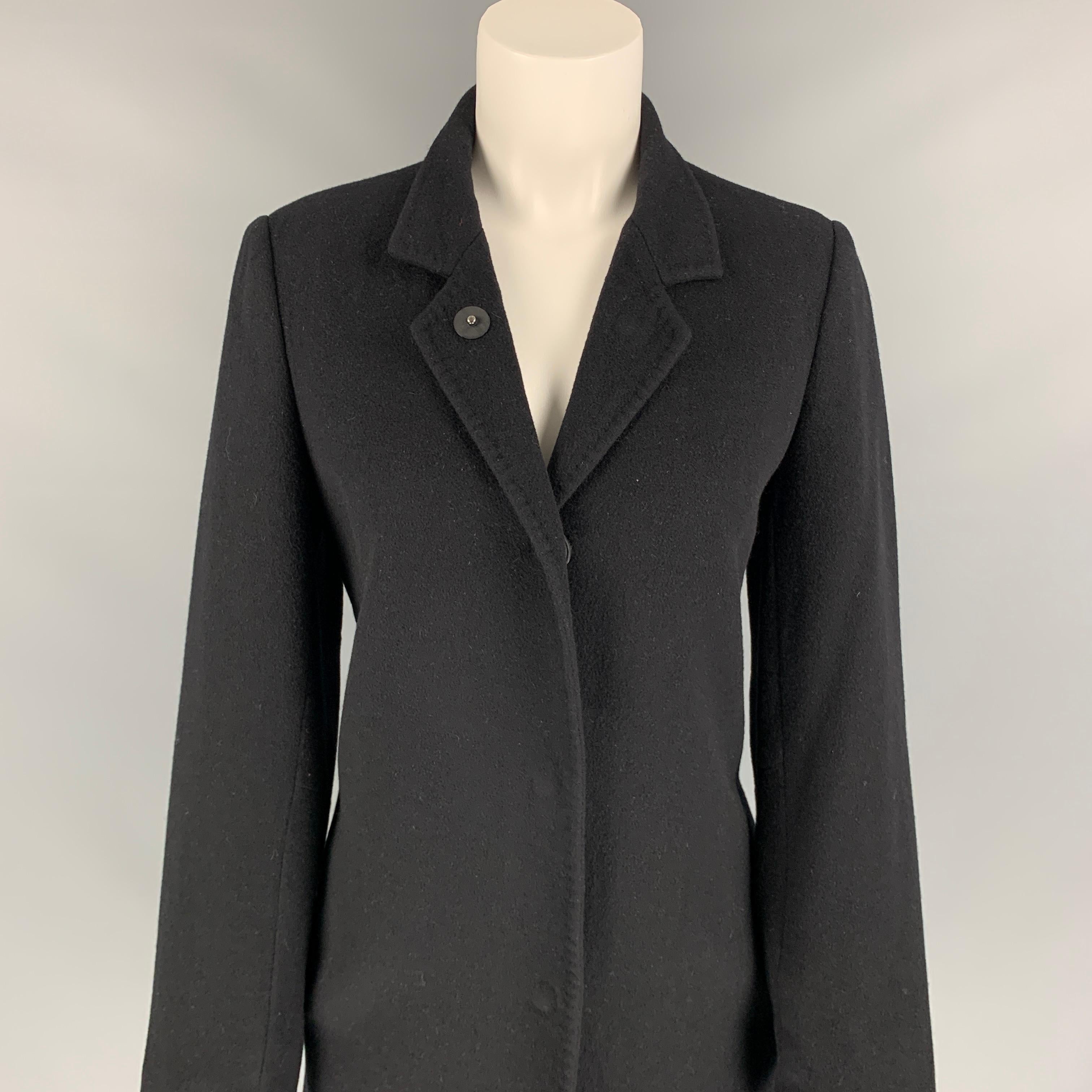 LAN JAENICKE coat comes in a black cashmere with a full liner featuring slit pockets, single back vent, and a hidden snap button closure. 

Very Good Pre-Owned Condition.
Marked: 2

Measurements:

Shoulder: 16 in.
Bust: 36 in.
Sleeve: 24 in.
Length:
