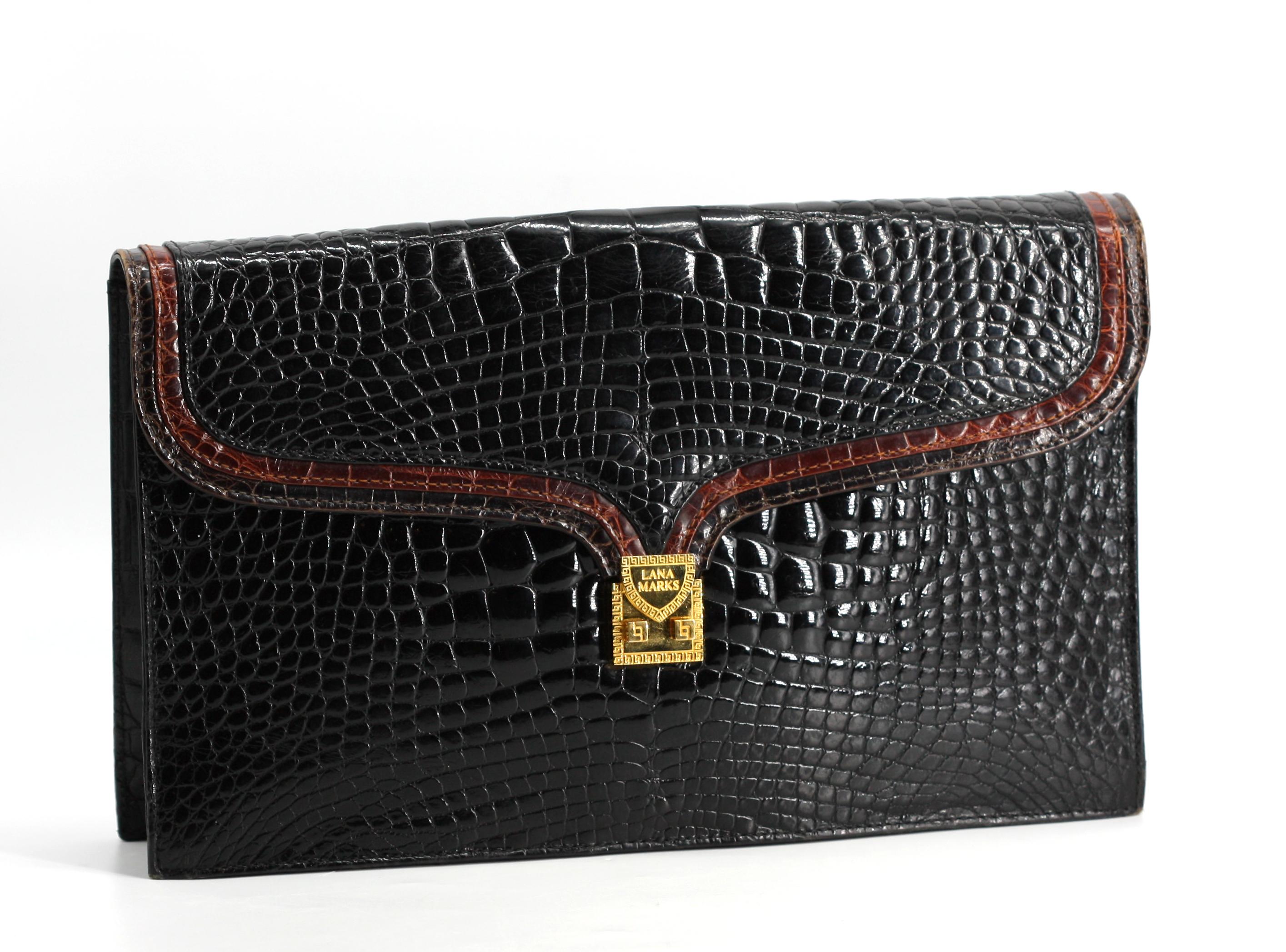 Large pochette en crocodile noir et marron de Lana Marks

Exemplaire de l'esthétique luxueuse du créateur, cette grande pochette rectangulaire est réalisée en crocodile noir et marron, le corps structuré par un rabat en forme et orné d'une