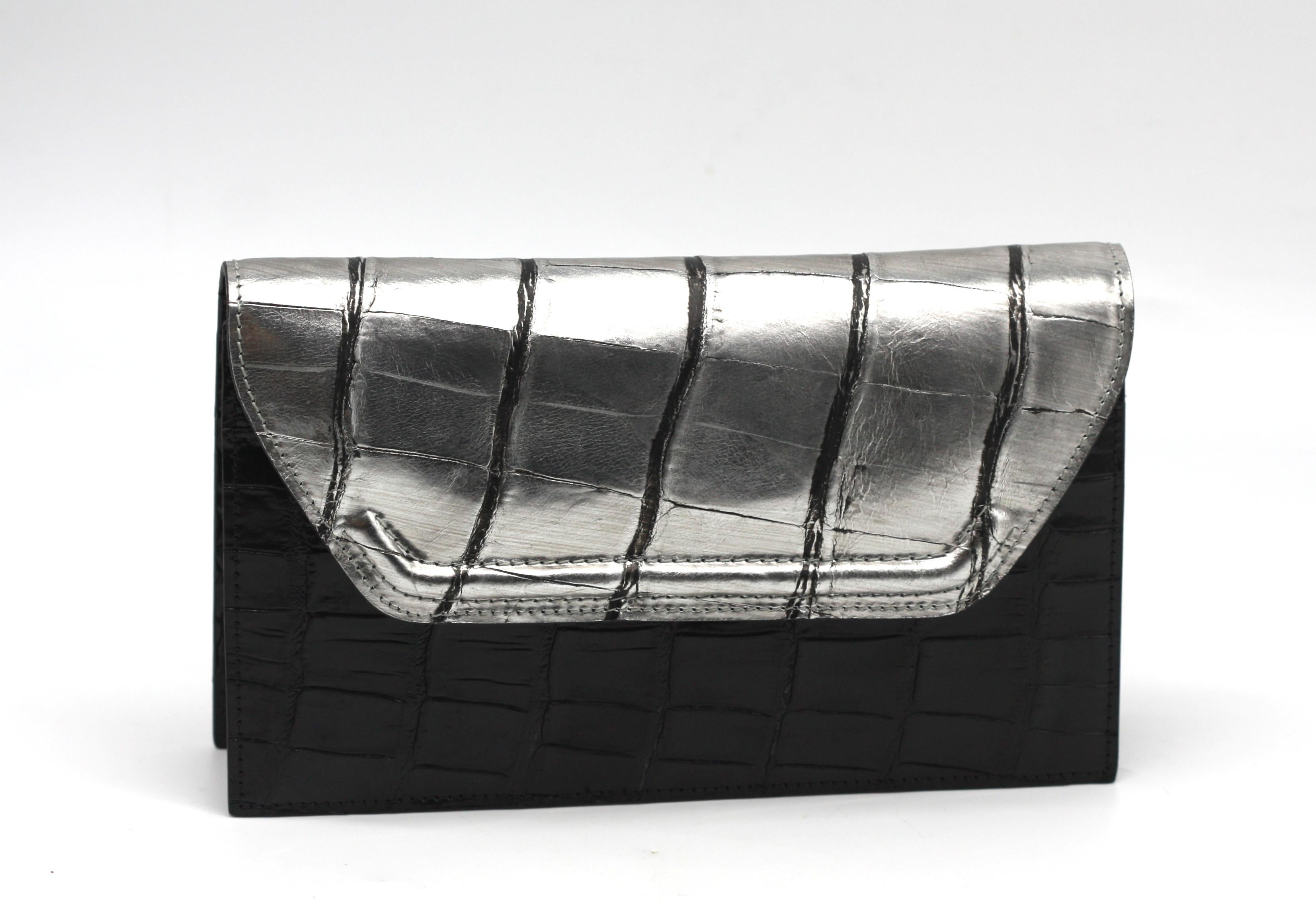 Lana Marks Silberne und schwarze Alligator-Kupplung

Eine elegante, rechteckige Abendtasche von Lana Marks, gefertigt aus Silber und schwarzem Alligatorleder. Die silberfarbene Klappe lässt sich öffnen und gibt den Blick auf das mit schwarzem Leder