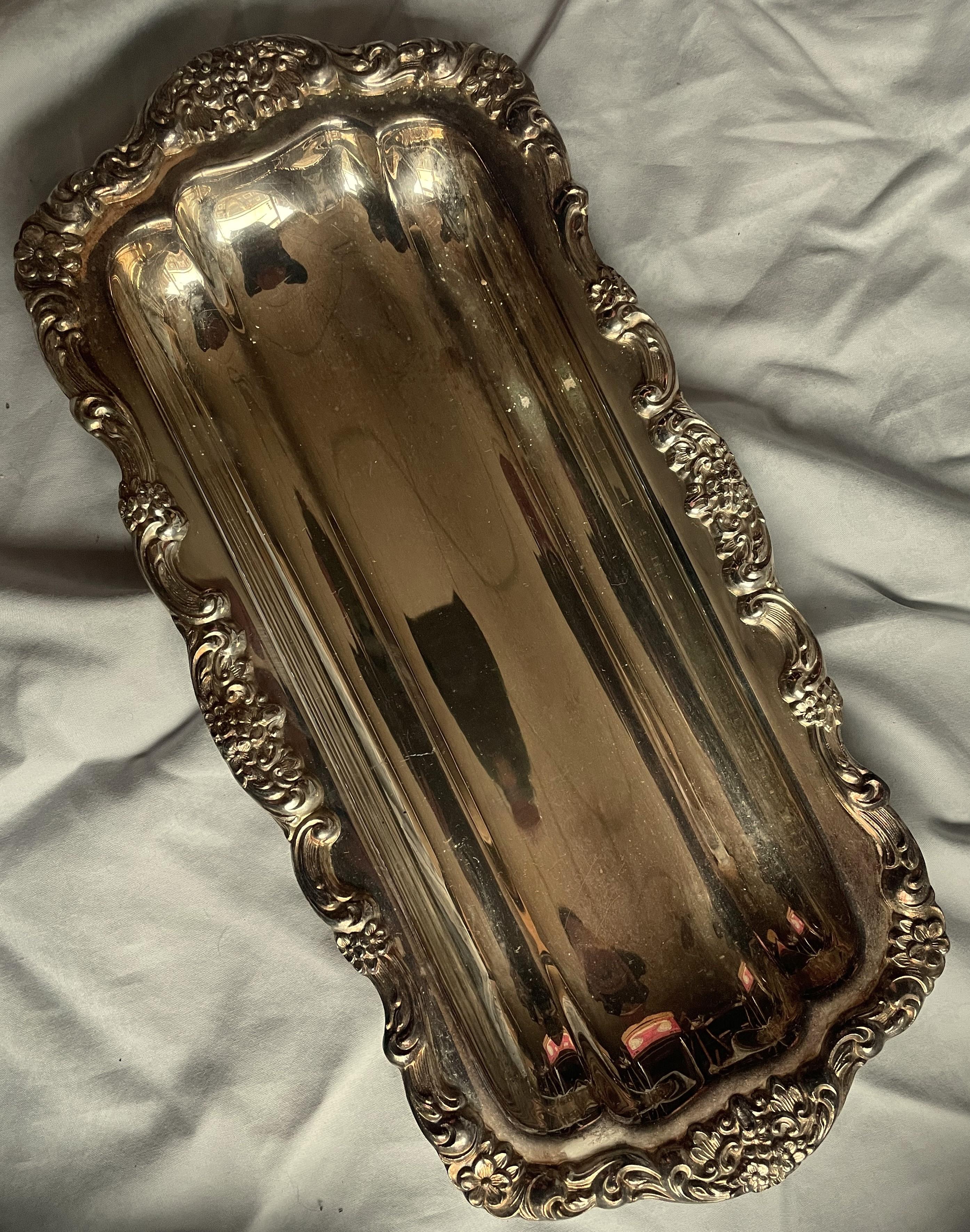 Il s'agit d'un très joli plat en métal argenté qui pourrait être utilisé pour servir presque n'importe quoi, mais il est plus long que large et les plats de cette forme étaient faits pour servir du céleri ou du pain. Celui-ci présente un joli motif