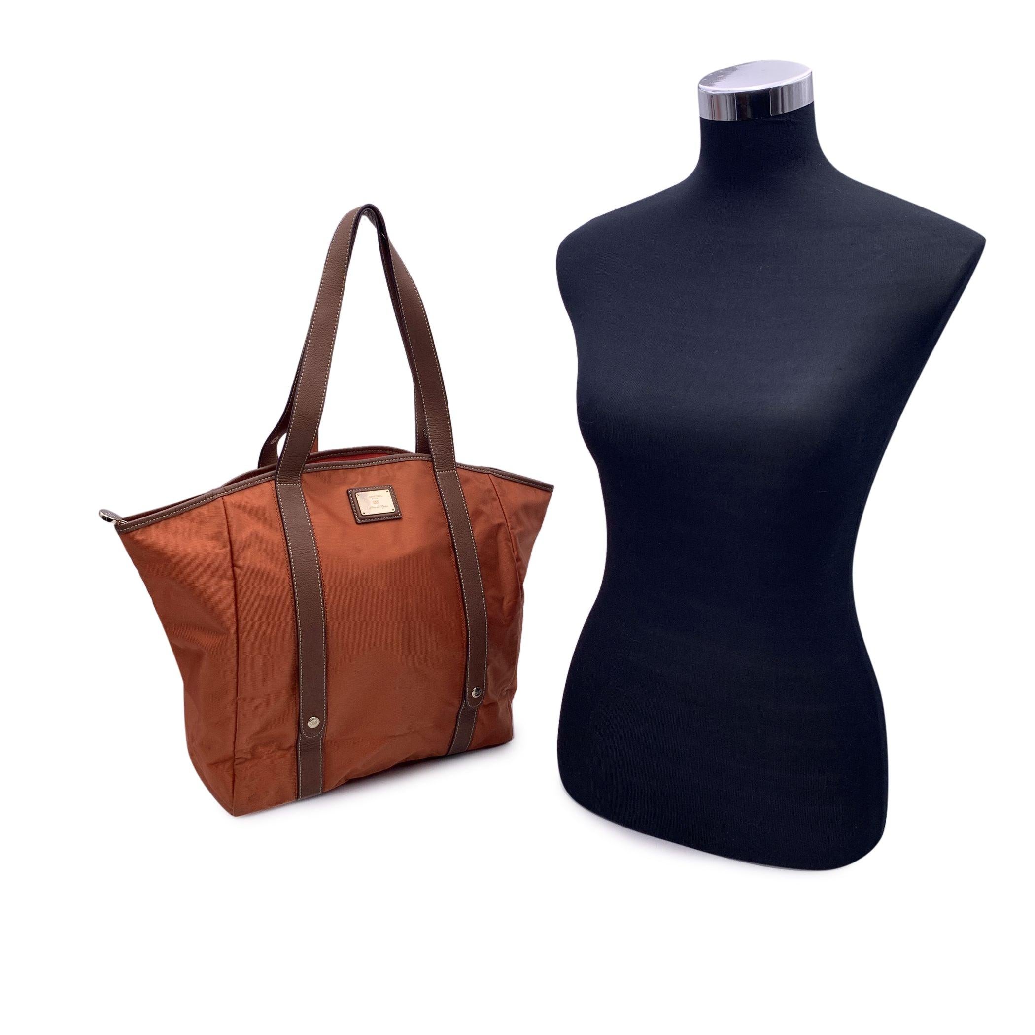 Lance 'Sac Rock and Roll' tote bag in orange nylon with brown leather trim and handles. From the 2011 Spring/Summer collection. Foldable model. It comes with a drawstring cylinder bag to easily roll up the tote bag into. Logo plate on the front.