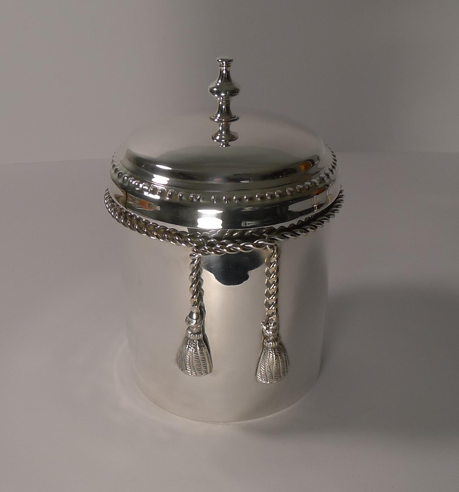 A stunning Mid-Century Modern silver plated covered box, beautifully decorative in the manner of the famous French designer, Maria Pergay.

The box with an applied rope with tassels to the front.

The underside is fully marked, Lancel,