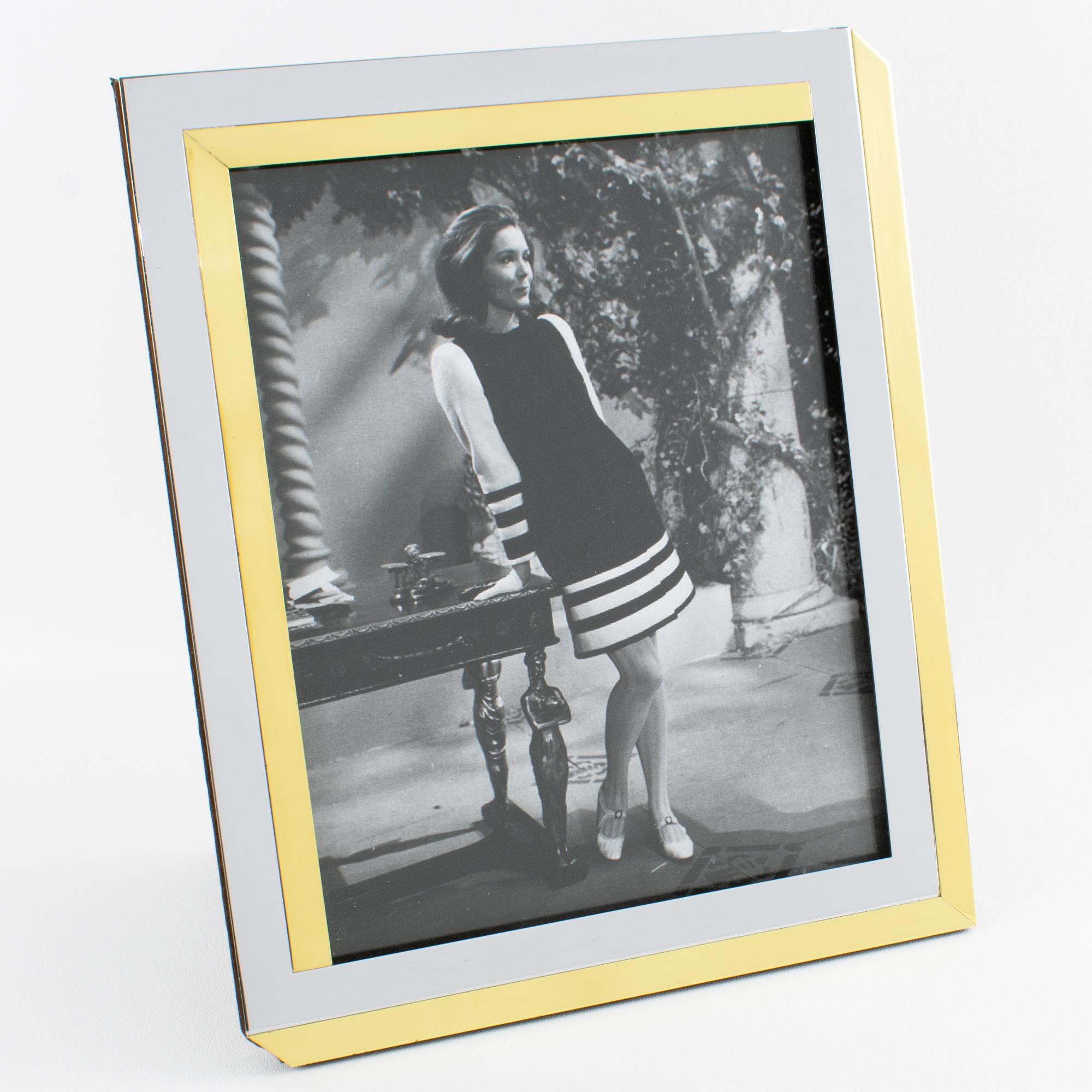 This stunning modernist picture frame was designed by the renowned French luxury company Lancel Paris. The piece was expertly crafted in France circa 1970. The gilded brass and chrome geometric design has a Kinetic effect. The easel and back are in