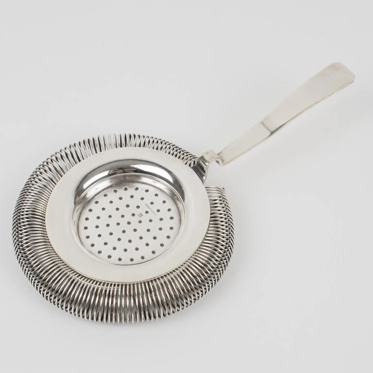 Maison Lancel, Paris, designed this silver plate cocktail strainer. Used on a Boston-type shaker, the strainer allows only the liquid to be poured into the glass, removing the ice. That's the perfect accessory to mix drinks and Martini cocktails.