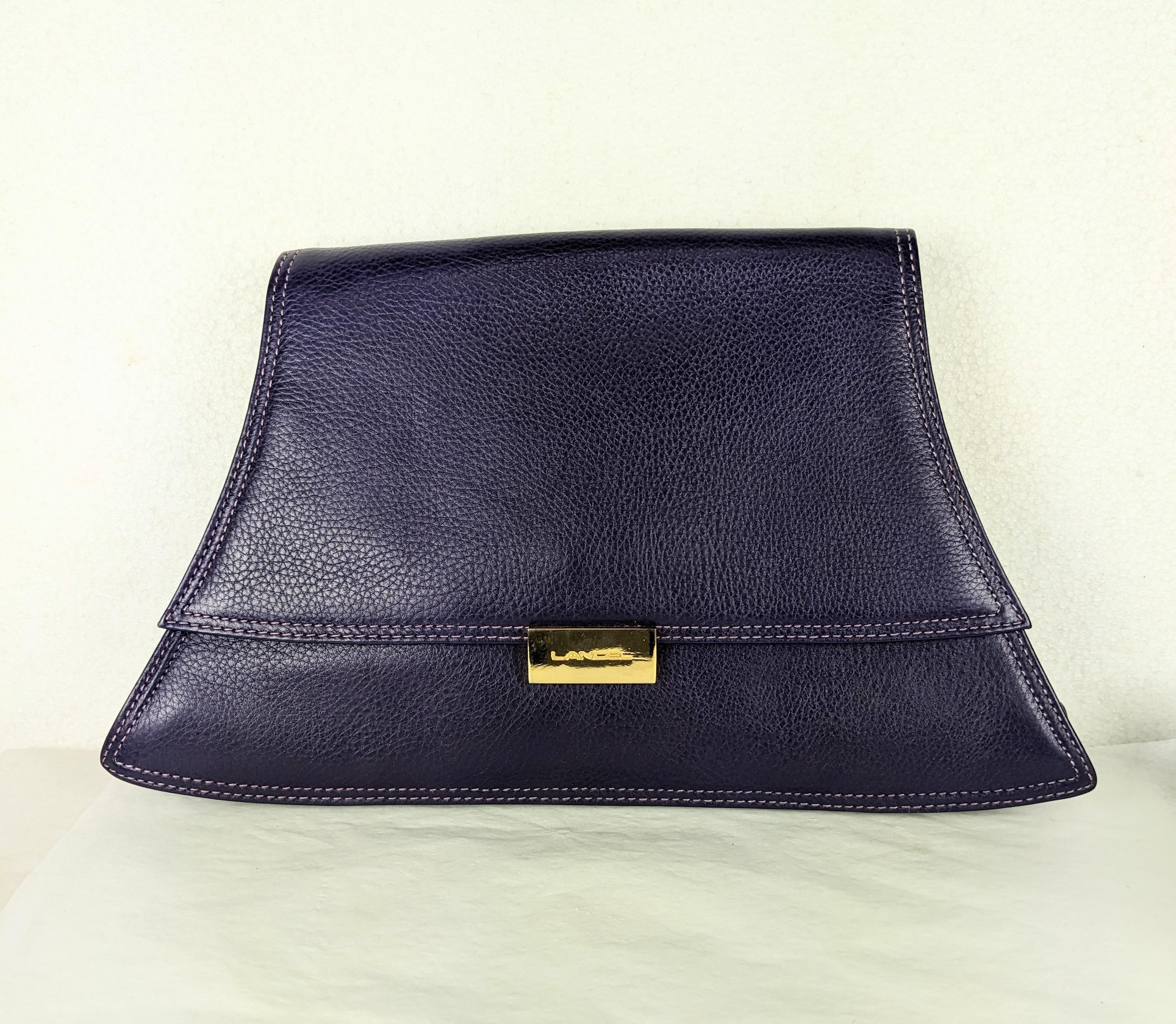 Lancel, Paris Purple Grained Leather Clutch in unusual shape from the early 2000's. Back outside slip pocket, magnetic closure, black leather lining with gold logo clasp. 
Top edge 8.5