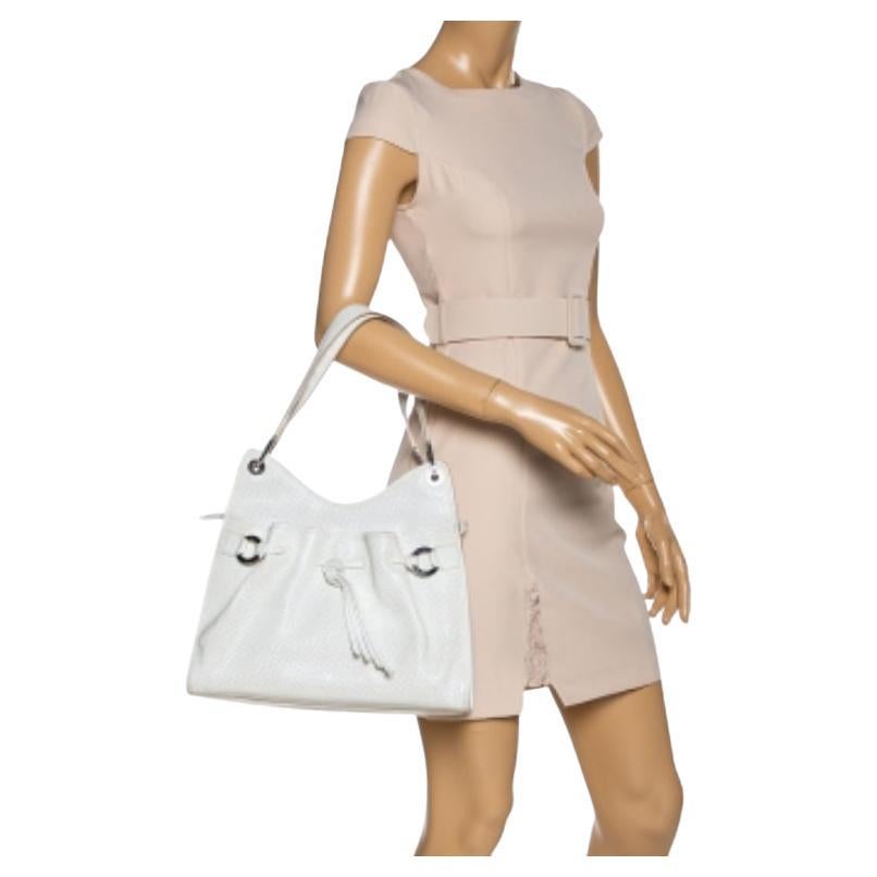 Featuring a trendy silhouette, this Lancel bag is crafted from durable leather and secured with a zipper. It comes with dual shoulder handles, drawstring detailing, and silver-tone hardware. Its nylon-lined interior can easily hold all your