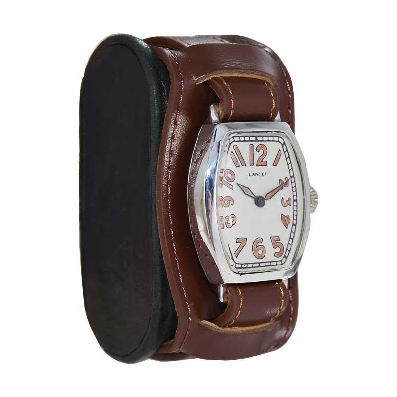 FACTORY / HOUSE: Lancet Watch Company
STYLE / REFERENCE: Tonneau / Art Deco 
METAL / MATERIAL: Sterling Silver
CIRCA / YEAR: 1920's
DIMENSIONS / SIZE: Length 27mm X Width 40mm
MOVEMENT / CALIBER: Manual Winding / 15 Jewels 
DIAL / HANDS: Silvered