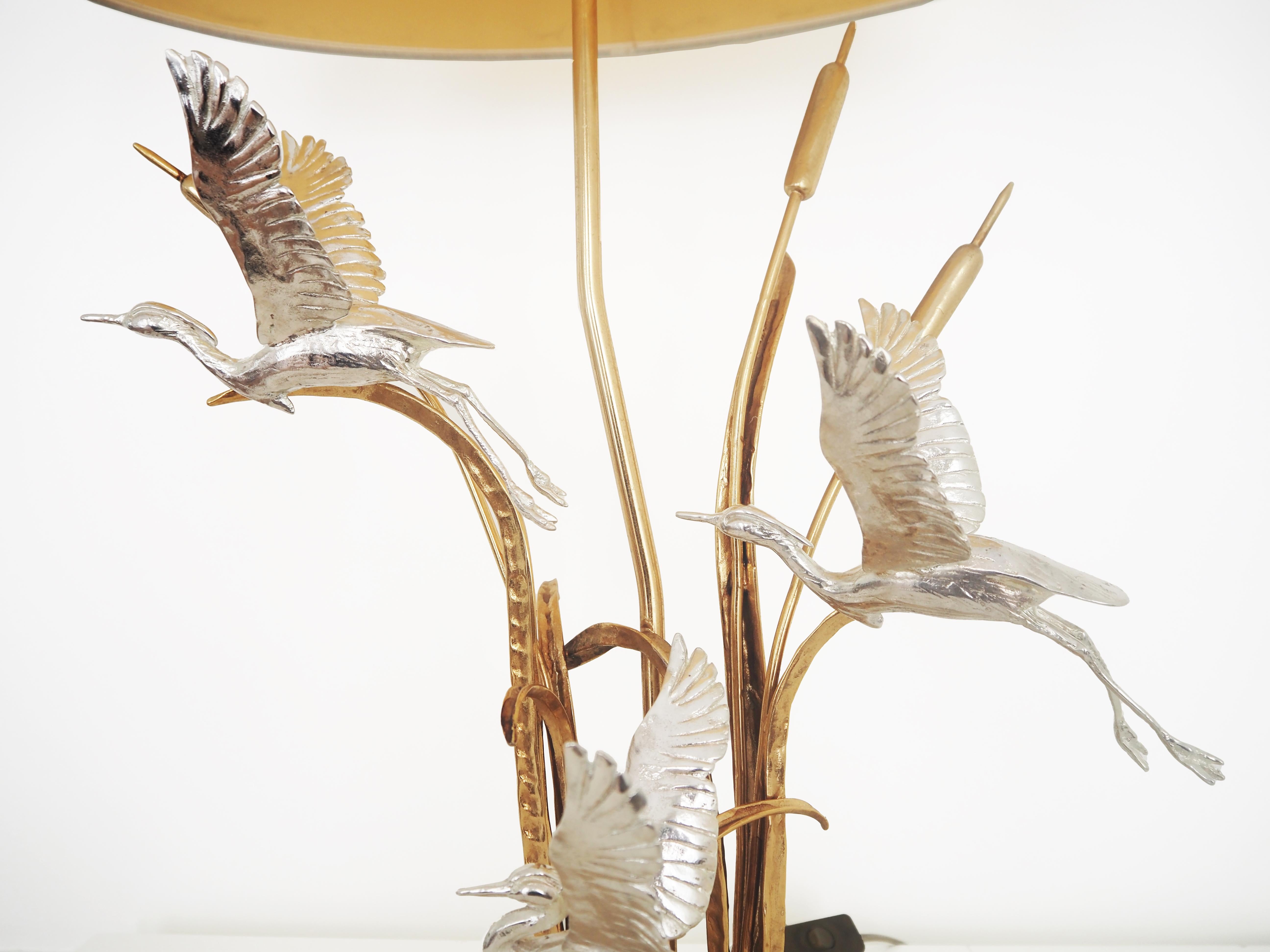 A rare and sculptural single-light table lamp by renowned Italian artist Lanciotto Galeotti, crafted in the 1970s. This elegant piece showcases exquisite detailing in gilded and silvered brass, featuring gracefully dynamic herons in flight set among